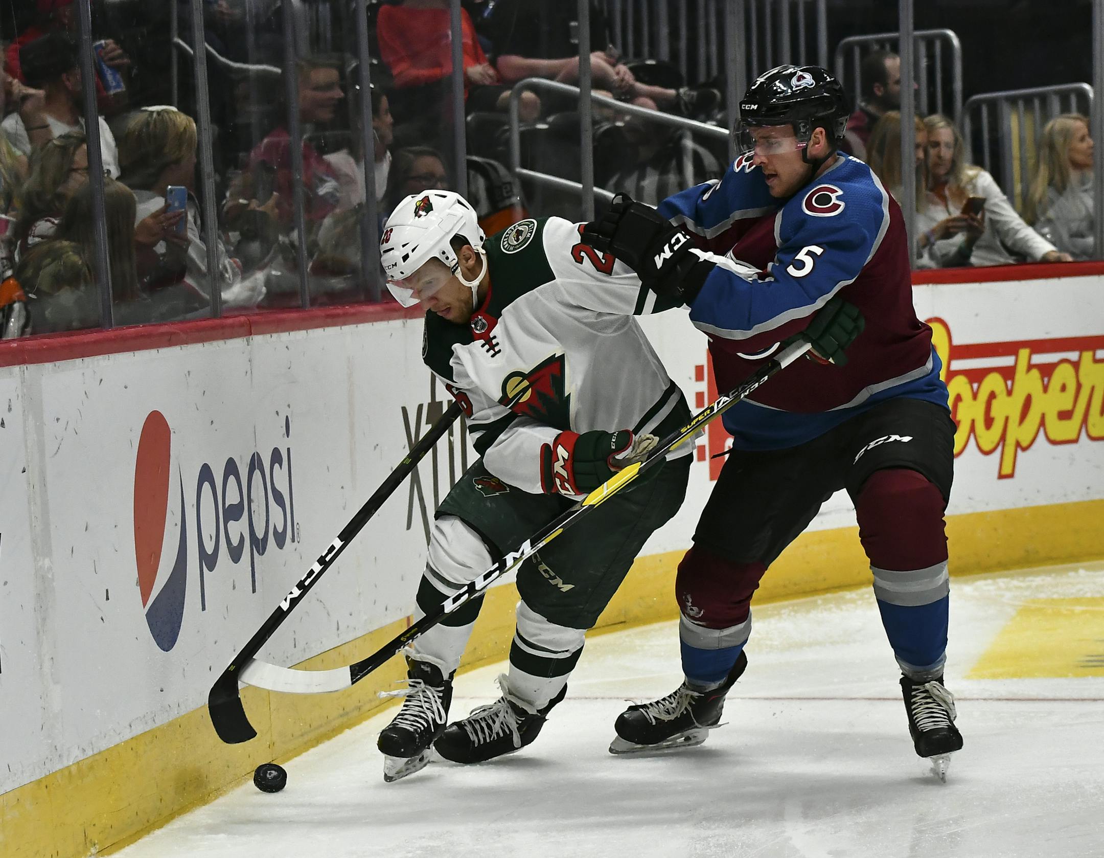 Minnesota Wild's Gerald Mayhew (26) battles for the puck along the boards with Colorado Avalanche defenseman Dan Renouf (5) during the second period in an NHL preseason hockey game Sunday, Sept. 22, 2019 in Denver (AP Photo/John Leyba)
