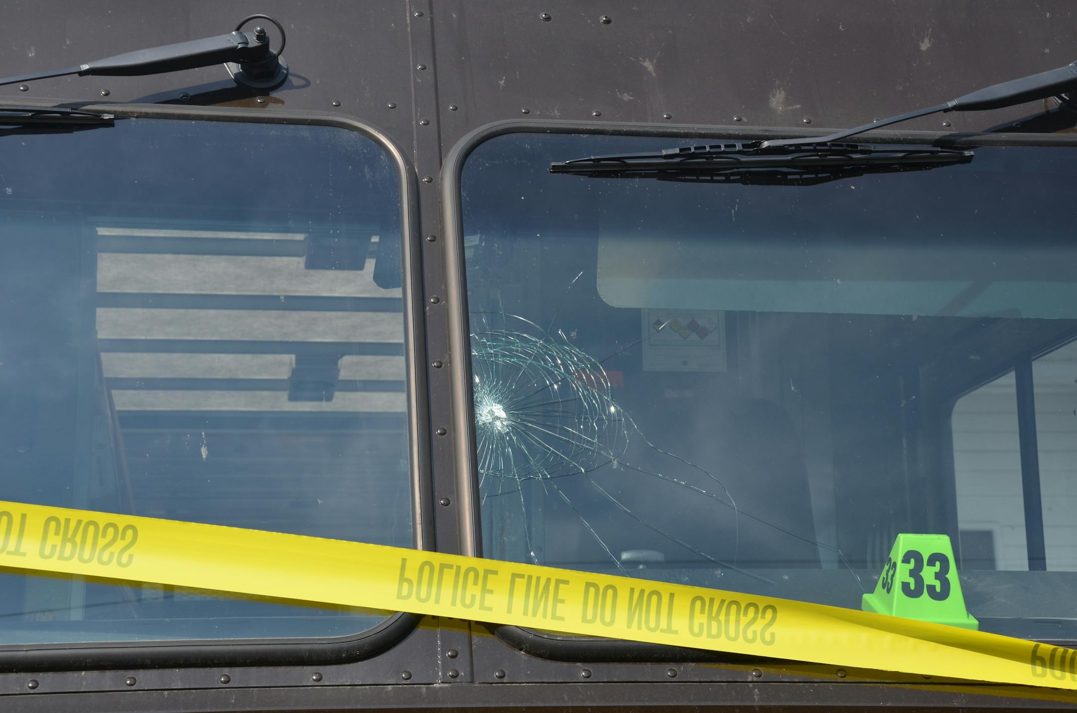 A bullet hole is shown in the windshield of a UPS truck outside Accent Signage.