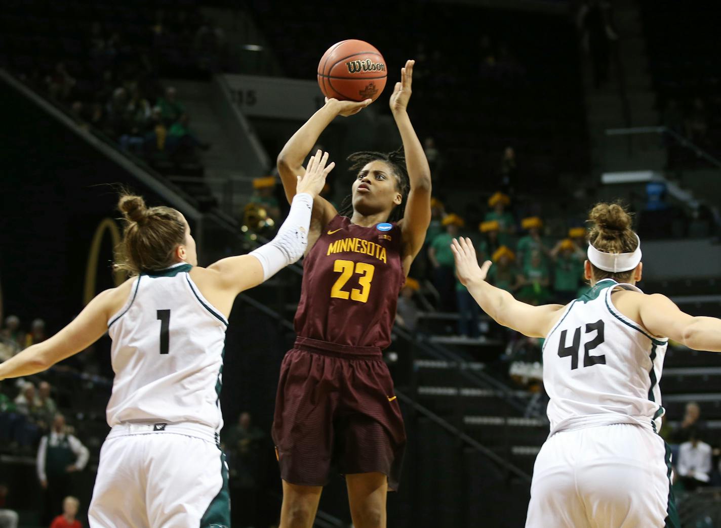 Minnesota's Kenisha Bell, center, shoots between Green Bay's Jen Wellnitz during the first-round matchup.