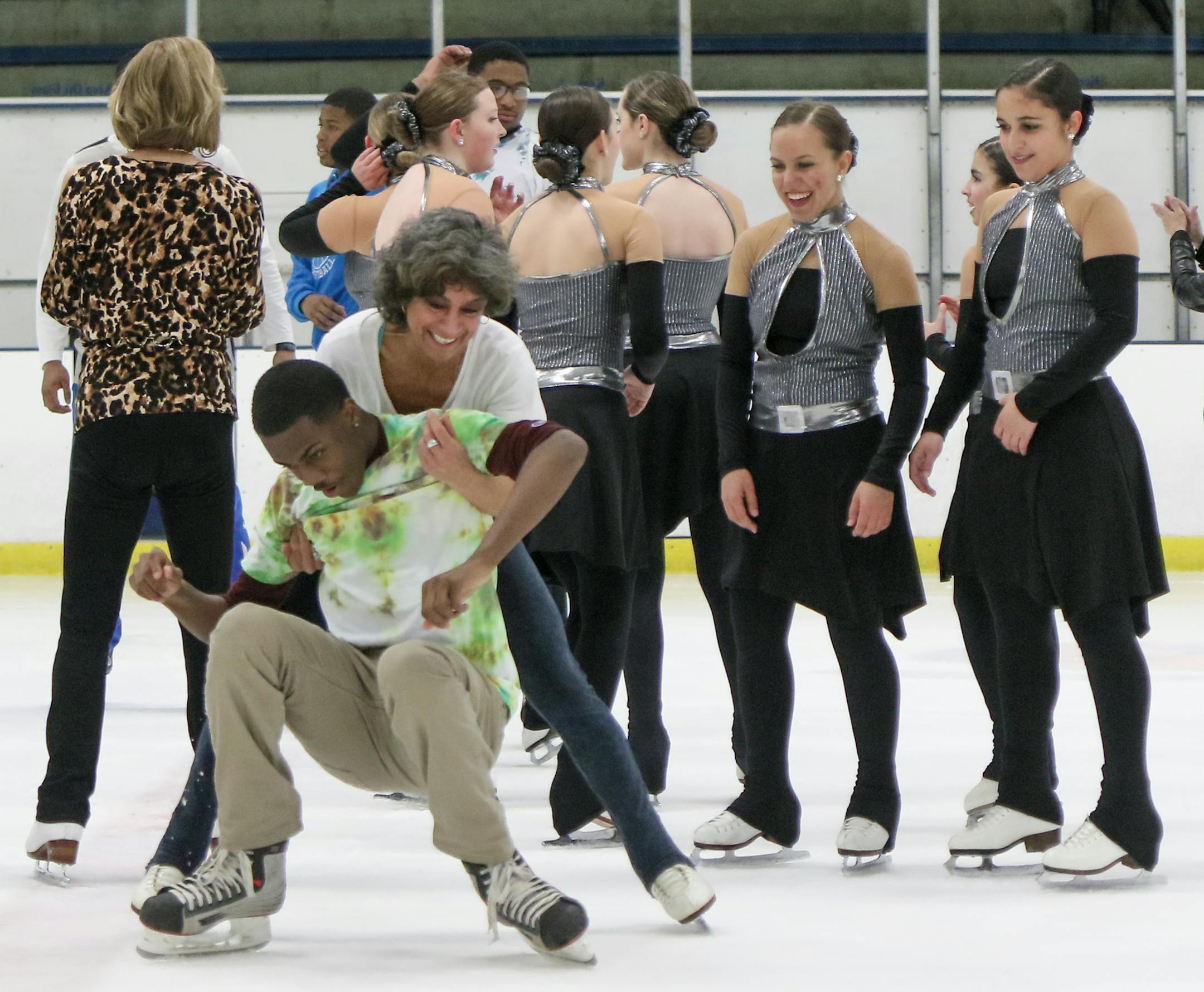 A helping hand: Minneapolis North basketball player Tyler Johnson was helped up by event organizer Jane Barrash. "Breaking the Ice: A (Skating) Show of Optimism" was held April 15 at Parade Ice Garden in Minneapolis as a way to foster community.