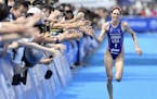 Gwen Jorgensen of St. Paul gave a high-five to spectators on her way to winning the world series triathlon in Yokohama for a consecutive fourth time o