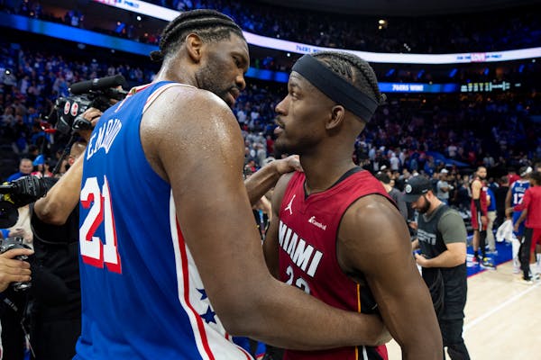 The 76ers' Joel Embiid, left, talks with the Heat's Jimmy Butler after host Philadelphia won the teams' NBA play-in game 105-104 on Wednesday night.