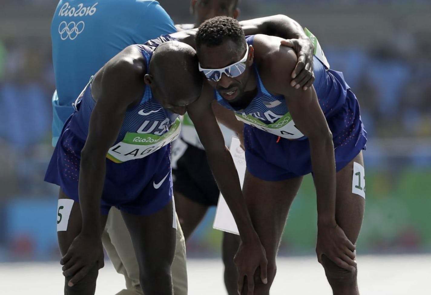 United States' Hassan Mead, right, finishes a men's 5000-meter heat after falling, is greeted by United States' Bernard Lagat during the athletics competitions of the 2016 Summer Olympics at the Olympic stadium in Rio de Janeiro, Brazil, Wednesday, Aug. 17, 2016.