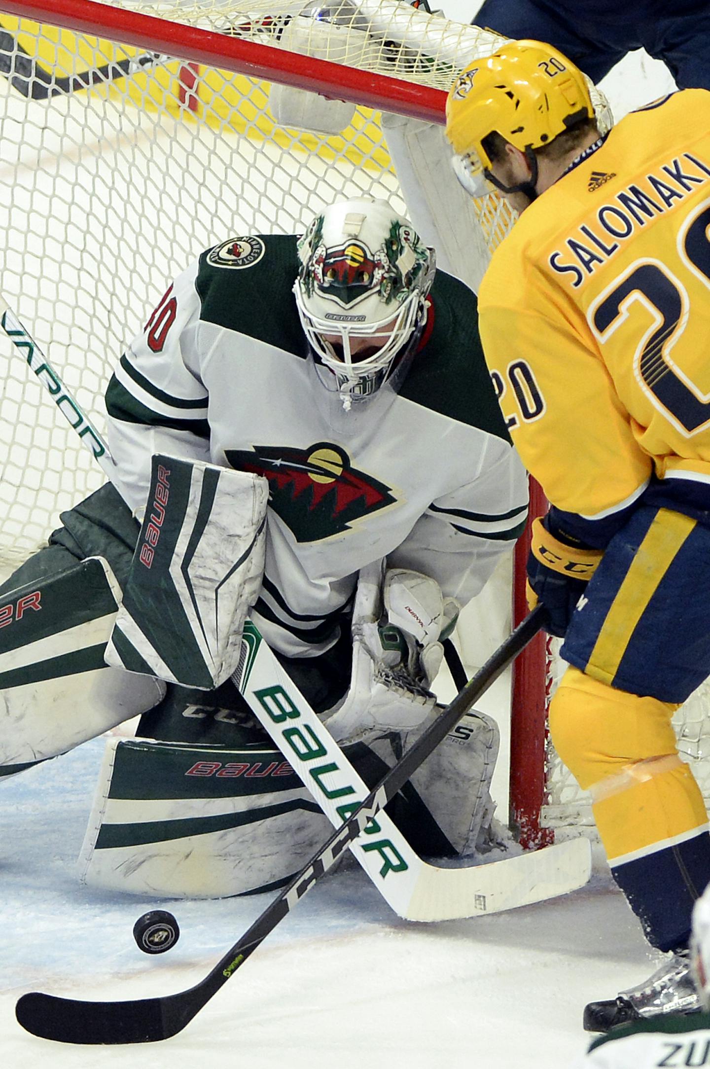 Minnesota Wild goaltender Devan Dubnyk (40) blocks a shot by Nashville Predators right wing Miikka Salomaki (20), of Finland, during the first period of an NHL hockey game Tuesday, March 27, 2018, in Nashville, Tenn. (AP Photo/Mark Zaleski)