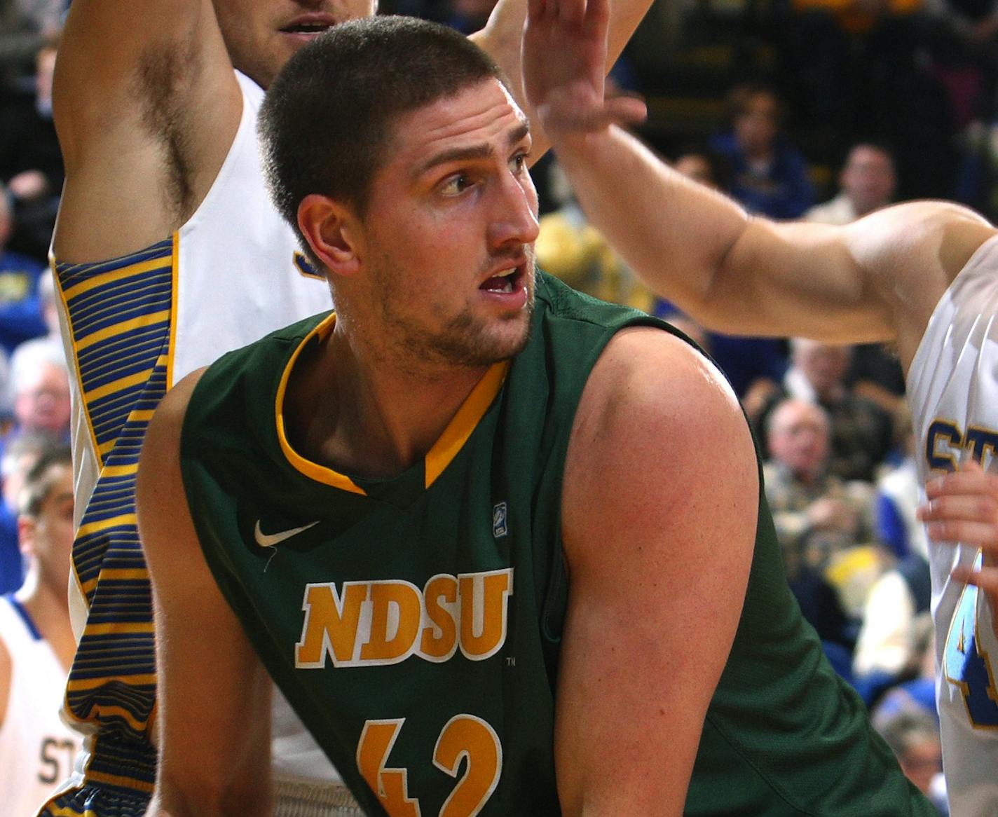 North Dakota State forward Marshall Bjorklund looks to pass the ball as South Dakota State forward Cody Larson, left, and guard Jake Bittle defend during the first half of an NCAA college basketball game at Frost Arena in Brookings, S.D., Saturday, Jan. 25, 2014. North Dakota State went on to beat South Dakota State 85-77. (AP Photo/Eric Landwehr) ORG XMIT: SDEL101