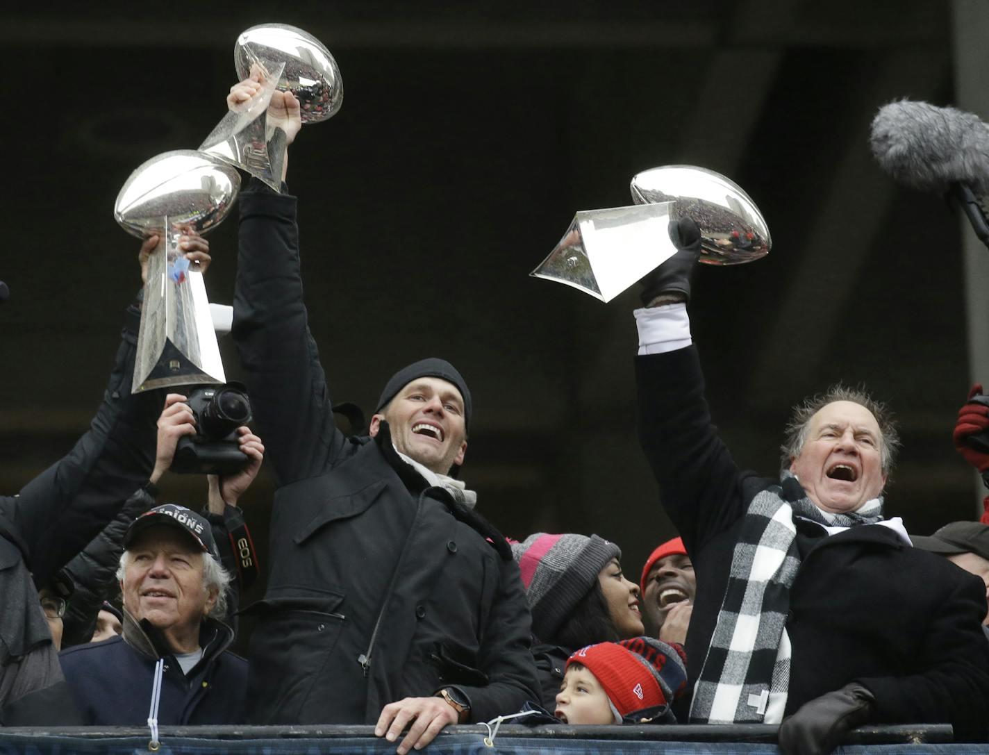 New England Patriots quarterback Tom Brady holds up Super Bowl trophies along with head coach Bill Belichick, right, and team owner Robert Kraft, left, during a rally Tuesday, Feb. 7, 2017, in Boston, to celebrate Sunday's 34-28 win over Atlanta.