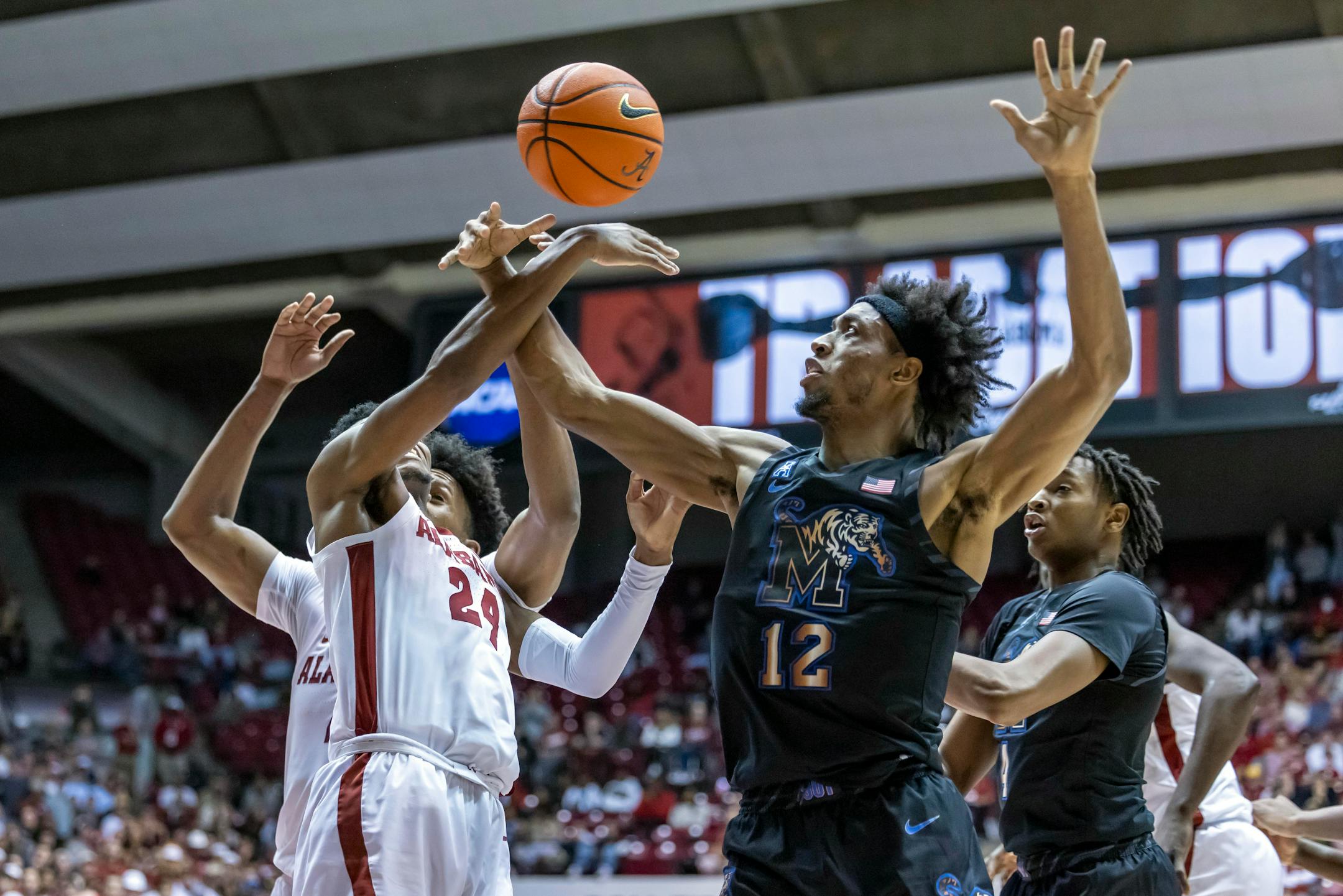 Memphis forward DeAndre Williams (12) battles Alabama forward Brandon Miller (24) for a rebound during the first half of an NCAA college basketball game, Tuesday, Dec. 13, 2022, in Tuscaloosa, Ala. (AP Photo/Vasha Hunt)