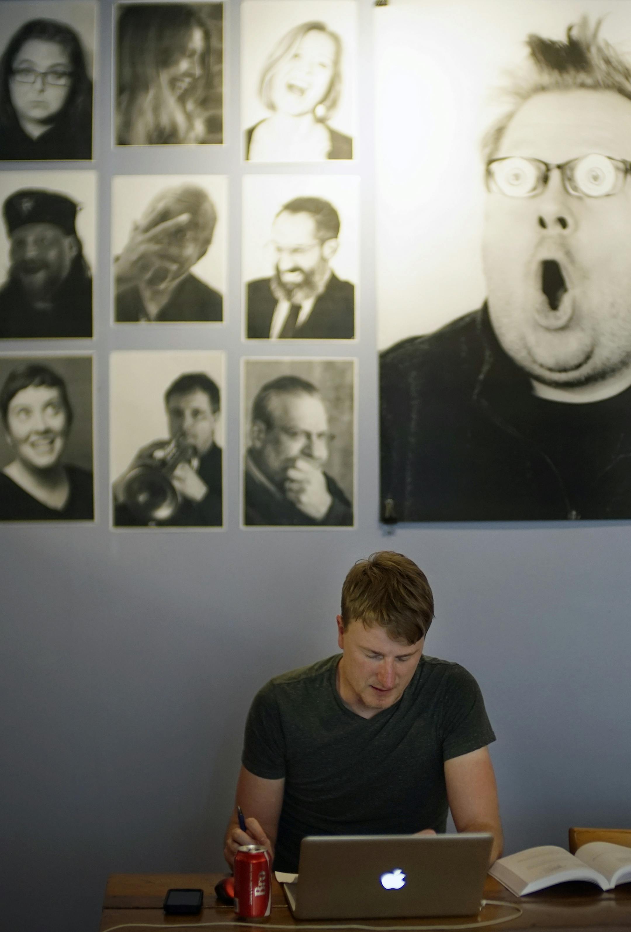 Lower town St. Paul has seen a revitalization that marks its as an increasingly popular oasis that celebrates art, music, good food. Plant pathology PhD student Kyle Haralson works on his thesis in front of some portraits from the Inside Out Lowertown project at the Black Dog Cafe. ] Richard Tsong-Taatarii/rtsong-taatarii@startribune.com