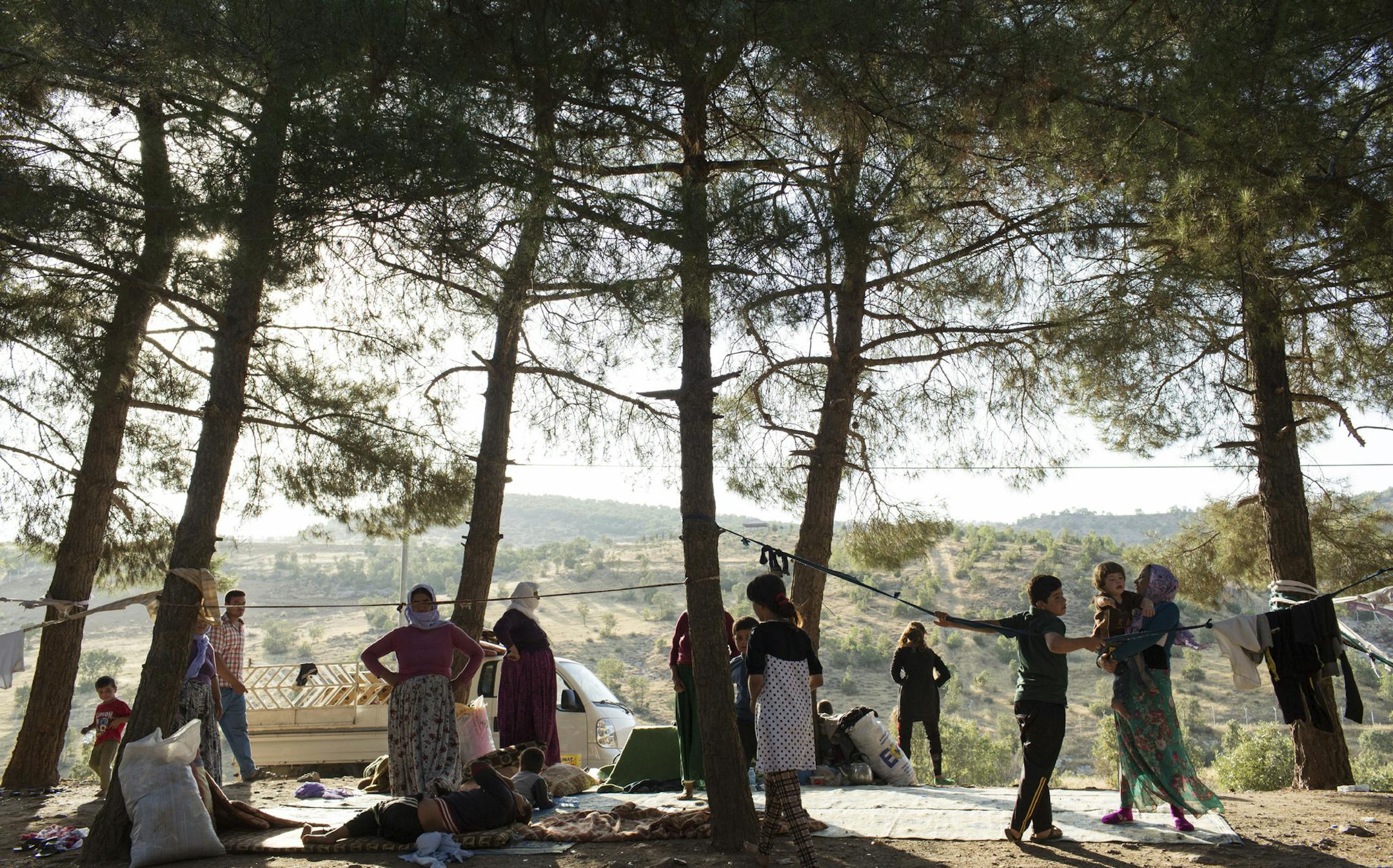Yazidi people who have fled from Islamic State forces take shelter by the roadside in Dohuk, Iraq, Aug. 8, 2014. Many members of religious minorities in northern Iraq have fled to Kurdish territory, where American aircraft have conducted bombing missions to assist the local pesh merga in combat against the Islamic State fighters. (Adam Ferguson/The New York Times)