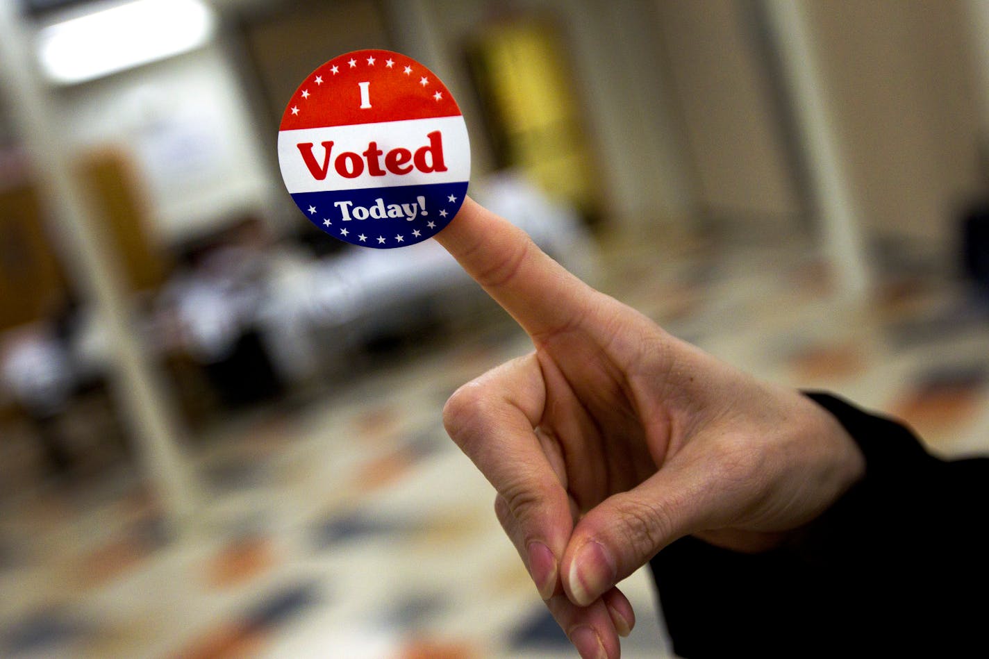 A voter displays a "I voted" sticker in a polling station at the Chinese Community Church in Washington, April 3, 2012. Voters are headed to the polls in Wisconsin, Maryland and Washington Tuesday to continue the narrowing of the field in the Republican presidential nominating contest. (Doug Mills/The New York Times)