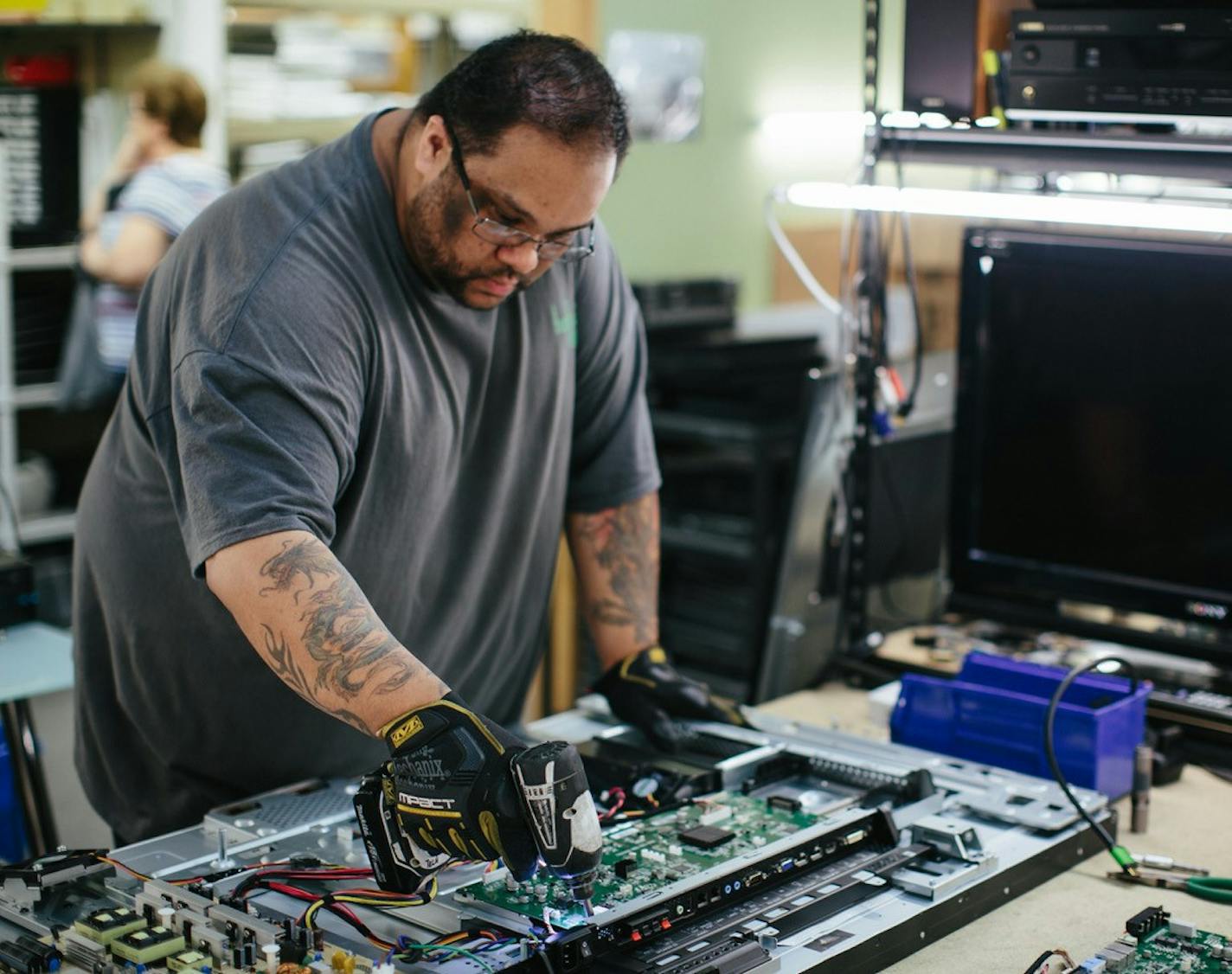 Electronic technician Alonzo Nelson of Tech Dump in St. Paul, repairs a flat-screen TV panel for resale at Tech Dump's used-electronics retail business. Photo: Monica Hubka