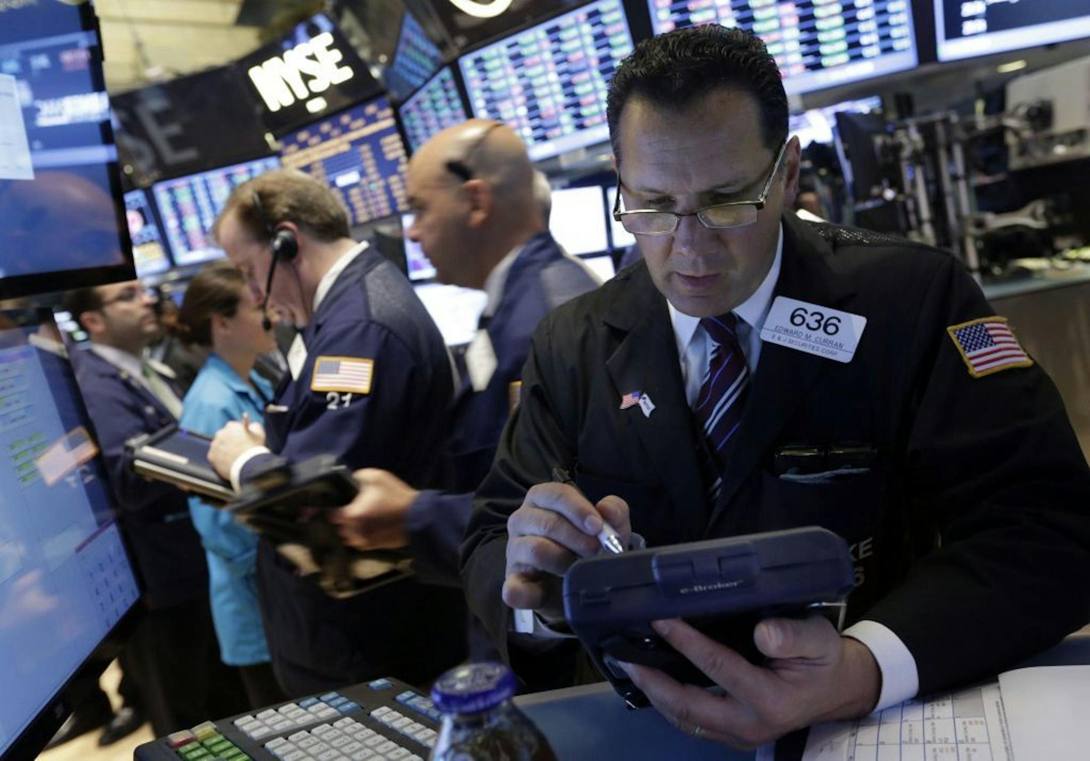 Trader Edward Curran, right, works on the floor of the New York Stock Exchange Wednesday, July 10, 2013. World stock markets eked out moderate gains Friday, July 12, 2013 building on a rally sparked by the Fed's vow to continue supporting the U.S. economy, as investors awaited the latest growth figures from China.