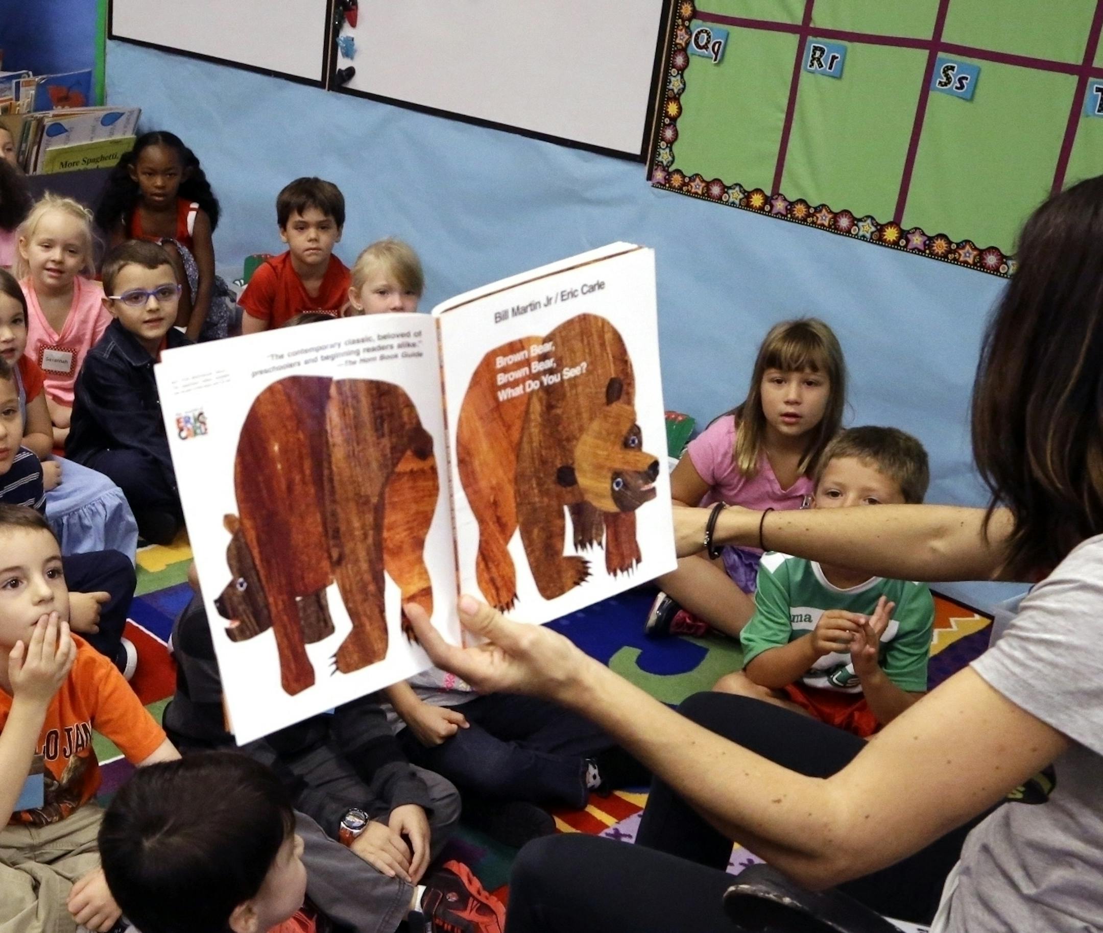 FILE - In this Sept. 8, 2015, file photo, kindergarten students listen as teacher Amy Holland reads on the first day of school at Nancy Ryles Elementary School in Beaverton, Ore. A last-minute amendment to the Republicans' tax plan would allow parents to use savings from 529 education savings accounts to pay for K-12 education, including homeschool expenses. It's been hailed as a win for school choice because it would expand a program that's been restricted to college tuition and expenses, altho
