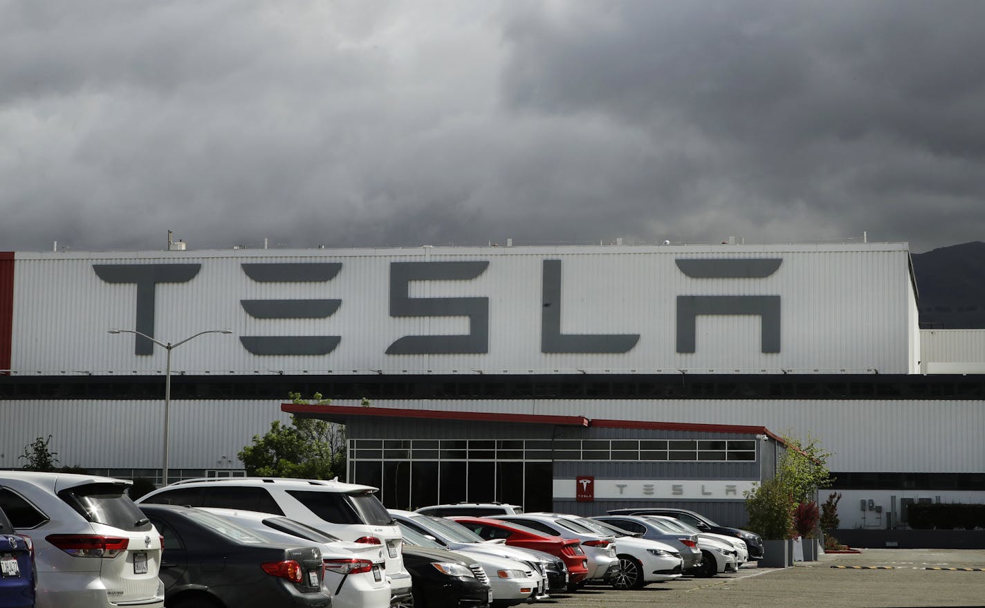 This photo shows the Tesla plant Tuesday, May 12, 2020, in Fremont, Calif. Tesla CEO Elon Musk has emerged as a champion of defying stay-home orders intended to stop the coronavirus from spreading. He reopened Tesla's San Francisco Bay Area factory on Monday and President Donald Trump is supporting that decision. (AP Photo/Ben Margot)