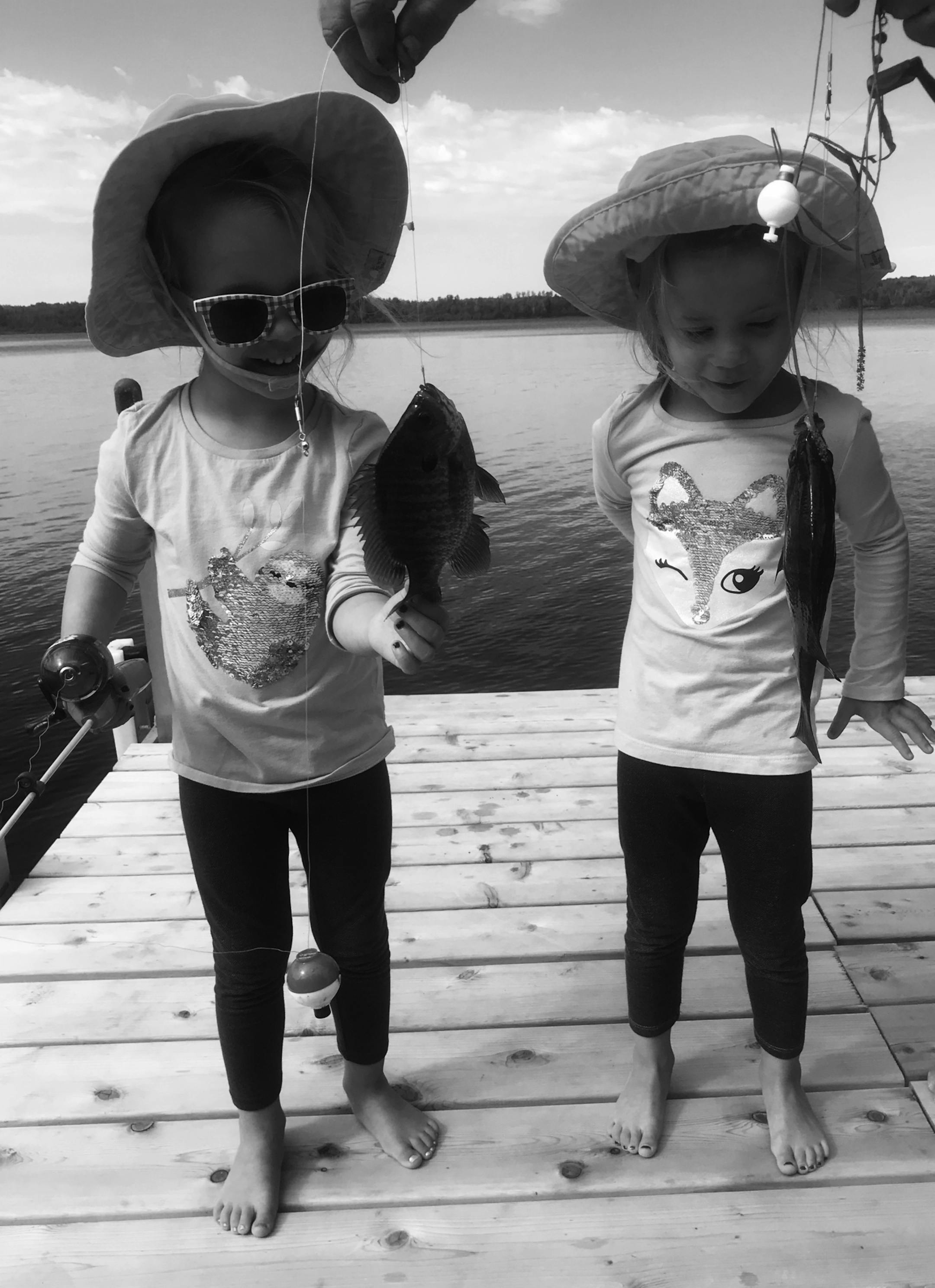Twin sisters Cecelia and Brooklyn Bordeaux, age 4, from Hugo, both caught sunfish while dock fishing on Park Lake near Mahtowa in Carlton County with their grandfather Jim Johnson.