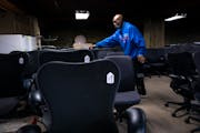 Aaron Mason, an employee at Furnish Office and Home, sorts office chairs from a new delivery into rows. The secondhand store in northeast Minneapolis 
