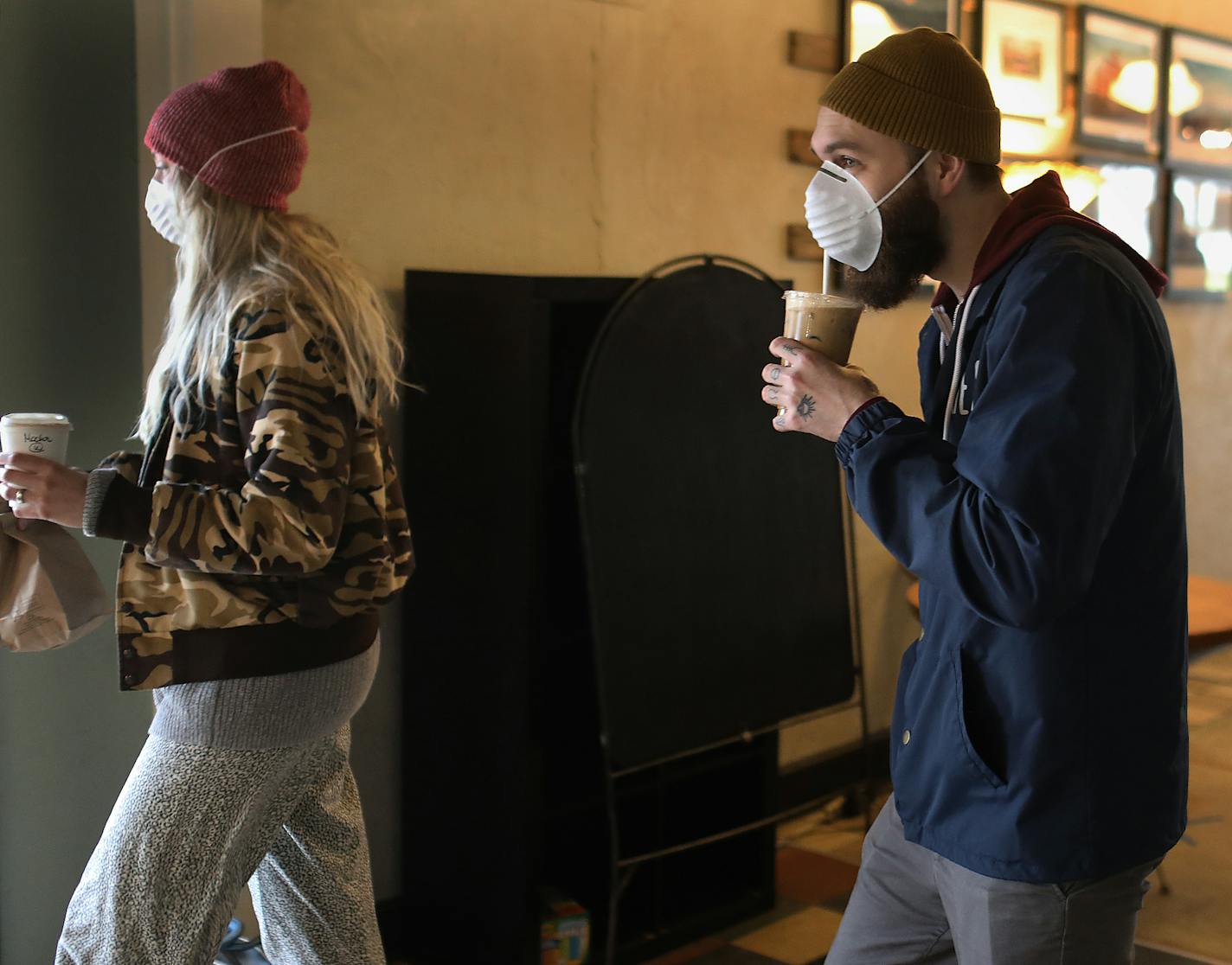 Royal Grounds coffee shop owners Jim and Joanne Heider, not pictured, have seen business drop by about 5o percent and had to let several employees go as they work to figure out ways to stay afloat during the Coronavirus pandemic. Here, regular customers Daniel, right, and Emily Landwehr, leave shop with their coffee fix Tuesday, April 28, 2020, in Minneapolis, MN.] DAVID JOLES &#x2022; david.joles@startribune.com Most independent coffee shops are shut down but a handful struggle to stay open. Fu