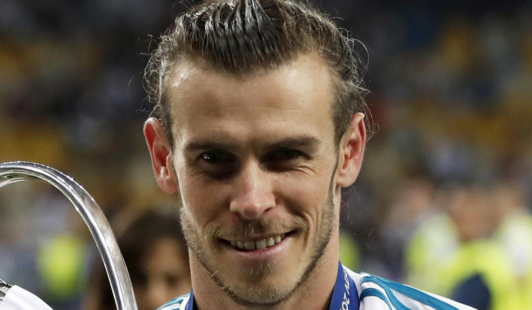 Real Madrid's Gareth Bale celebrates with the trophy after winning the Champions League Final soccer match between Real Madrid and Liverpool at the Olimpiyskiy Stadium in Kiev, Ukraine, Saturday, May 26, 2018. (AP Photo/Pavel Golovkin)