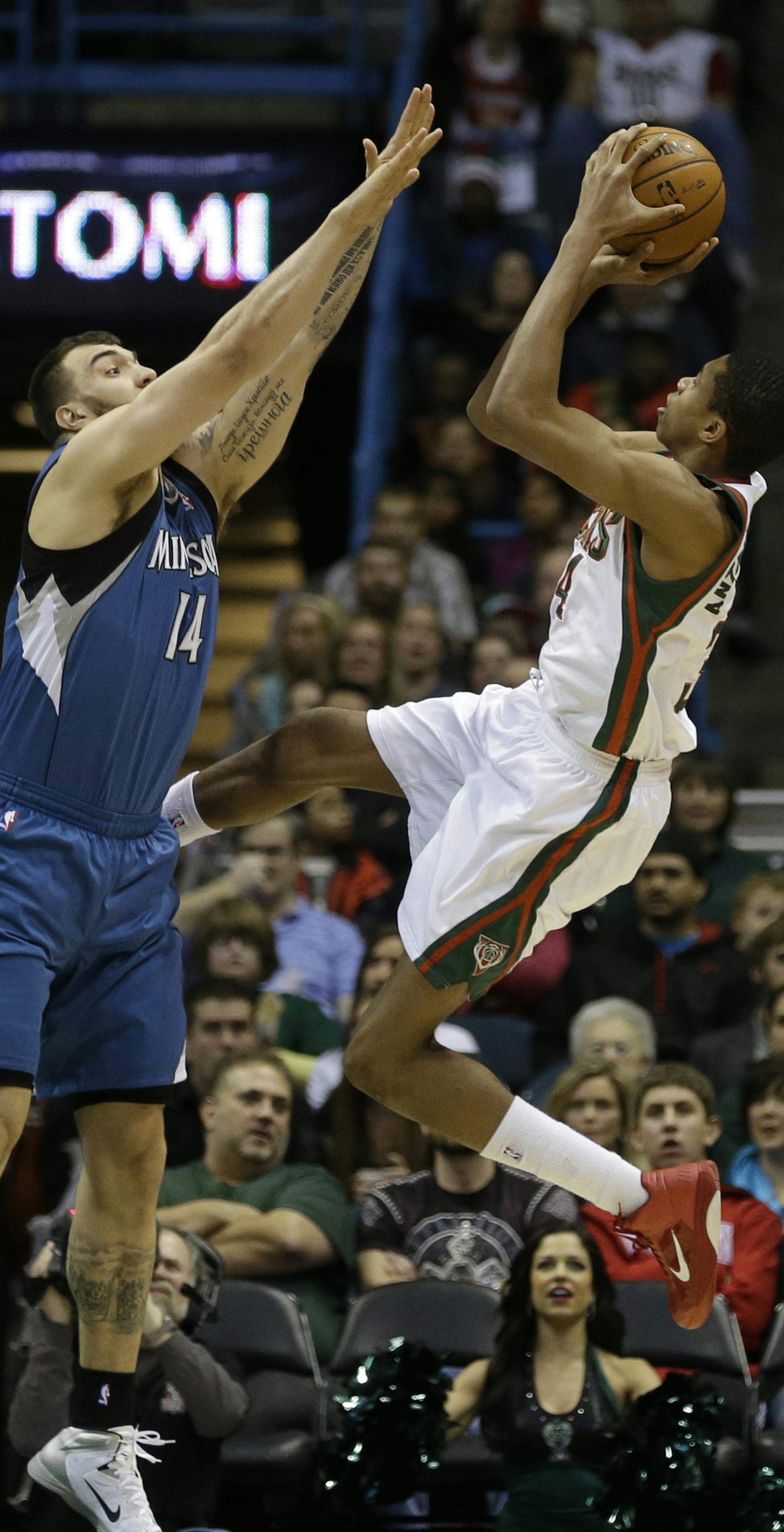 Milwaukee Bucks' Giannis Antetokounmpo, right, puts up a shot against Minnesota Timberwolves' Nikola Pekovic (14) during the first half of an NBA basketball game, Saturday, Dec. 28, 2013, in Milwaukee. (AP Photo/Jeffrey Phelps) ORG XMIT: WIJP104