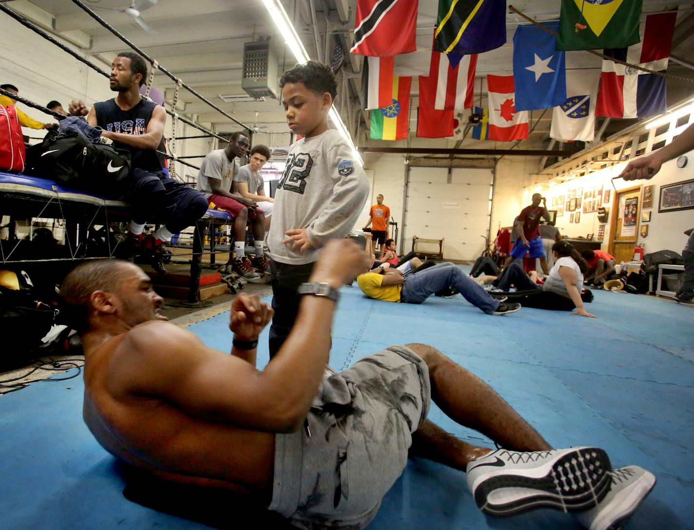 DeParis Frazier, 6, nephew of trainer Adonis Frazier, kept a close eye on Dwight Lewis as the fighter from South St. Paul did abdominal work. The flags of 50-some nations hang from the gym&#x2019;s rafters.