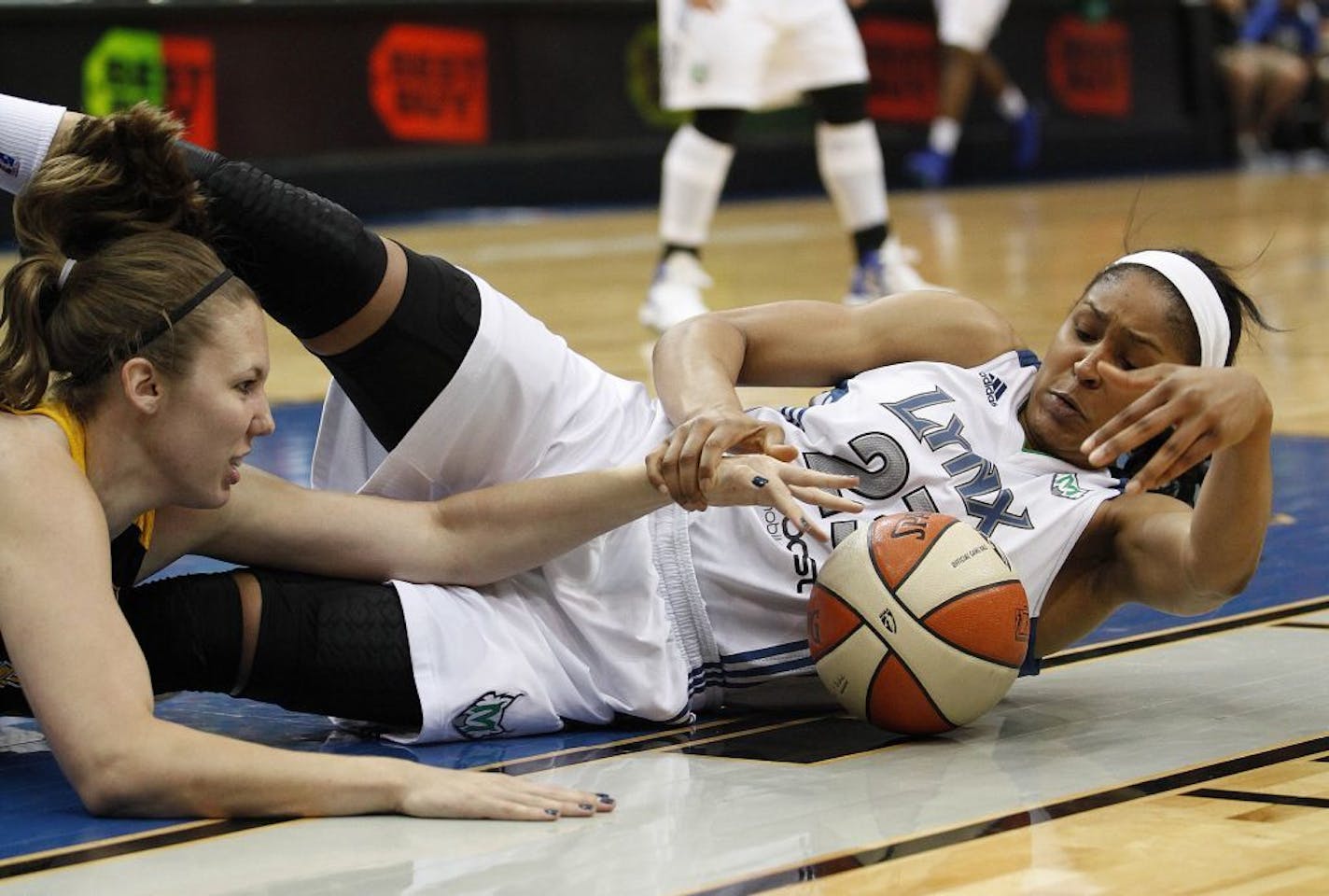 Minnesota Lynx forward Maya Moore (23) fights for a loose ball with Tulsa Shock forward Kayla Pedersen, left, during the first half of a WNBA basketball game, Thursday, July 12, 2012, in Minneapolis.