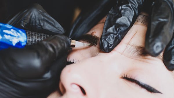 A microblading artist fills up the shape of an eyebrow with pigment as part of this semi-permanent makeup procedure.