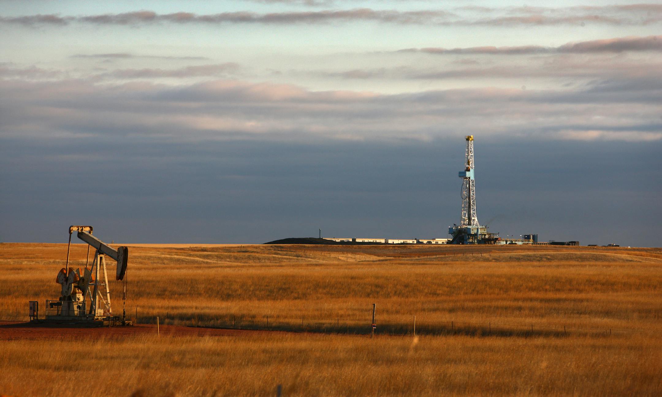 An oil drilling rig stands on the Bakken formation in Watford City, North Dakota, U.S., on Friday, Oct. 14, 2011. Oil production in the state has tripled in five years, attracting the likes of Exxon Mobil Corp., and Norway's Statoil ASA, which agreed this week to pay $4.5 billion for Brigham Exploration Co., one of the companies that figured out how tap dense rock that the U.S. Geological Survey has estimated may contain 4.3 billion barrels of oil. The productive Bakken formation stretches from