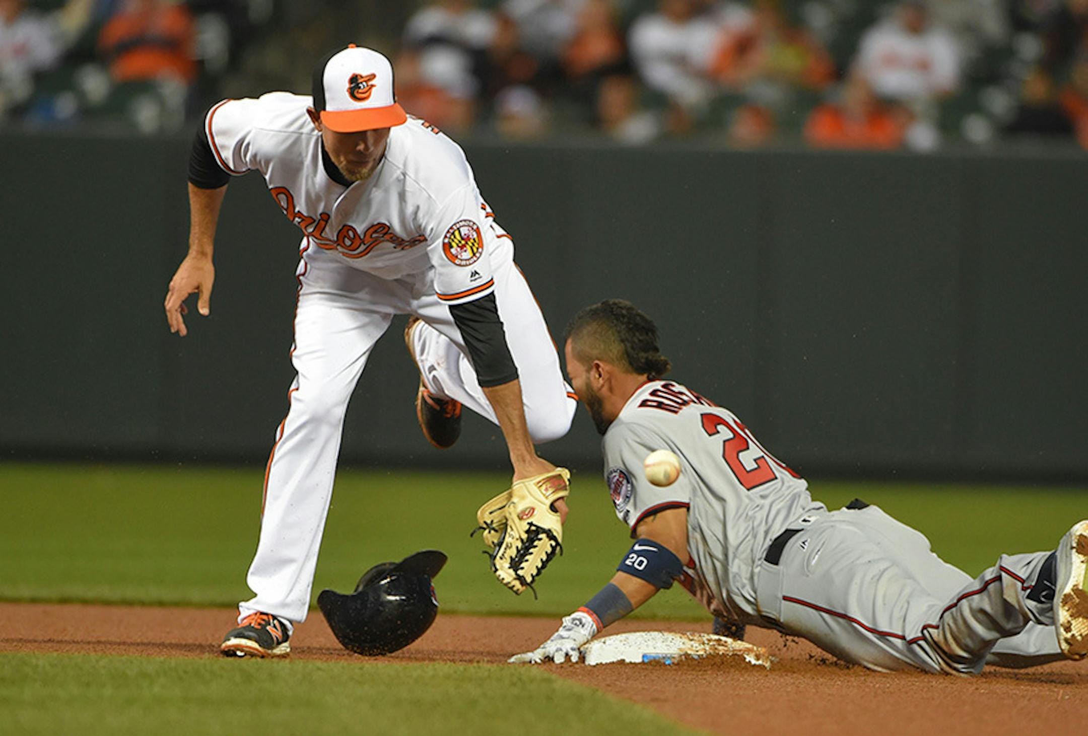 Baltimore Orioles' J.J. Hardy is unable to handle a throw as Minnesota Twins' Eddie Rosario slides in with a double during the seventh inning on Monday, April 4, 2016, at Oriole Park at Camden Yards in Baltimore.