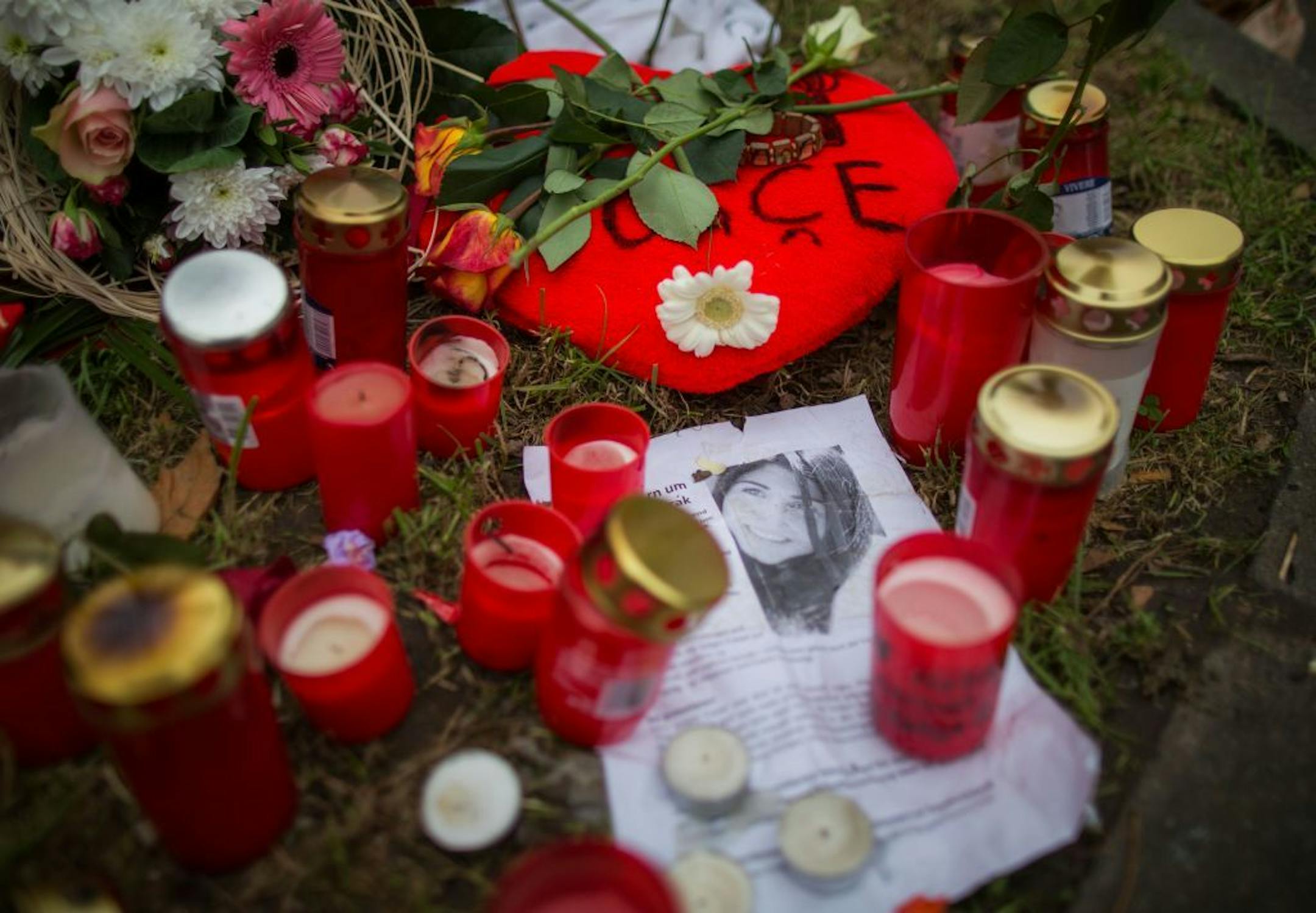 Candles and flowers are placed on the parking lot where Tugce was fatally injured two weeks ago in Offenbach, Germany, Monday Dec.1, 2014. Germany's president is considering awarding a posthumous medal to the young woman killed after defending two teenage girls from male harassment. German news agency dpa reported Sunday that President Joachim Gauck was mulling the honor amid an outpouring of public outrage over the killing. Student teacher Tugce Albayrak died Friday, her 23rd birthday, after he