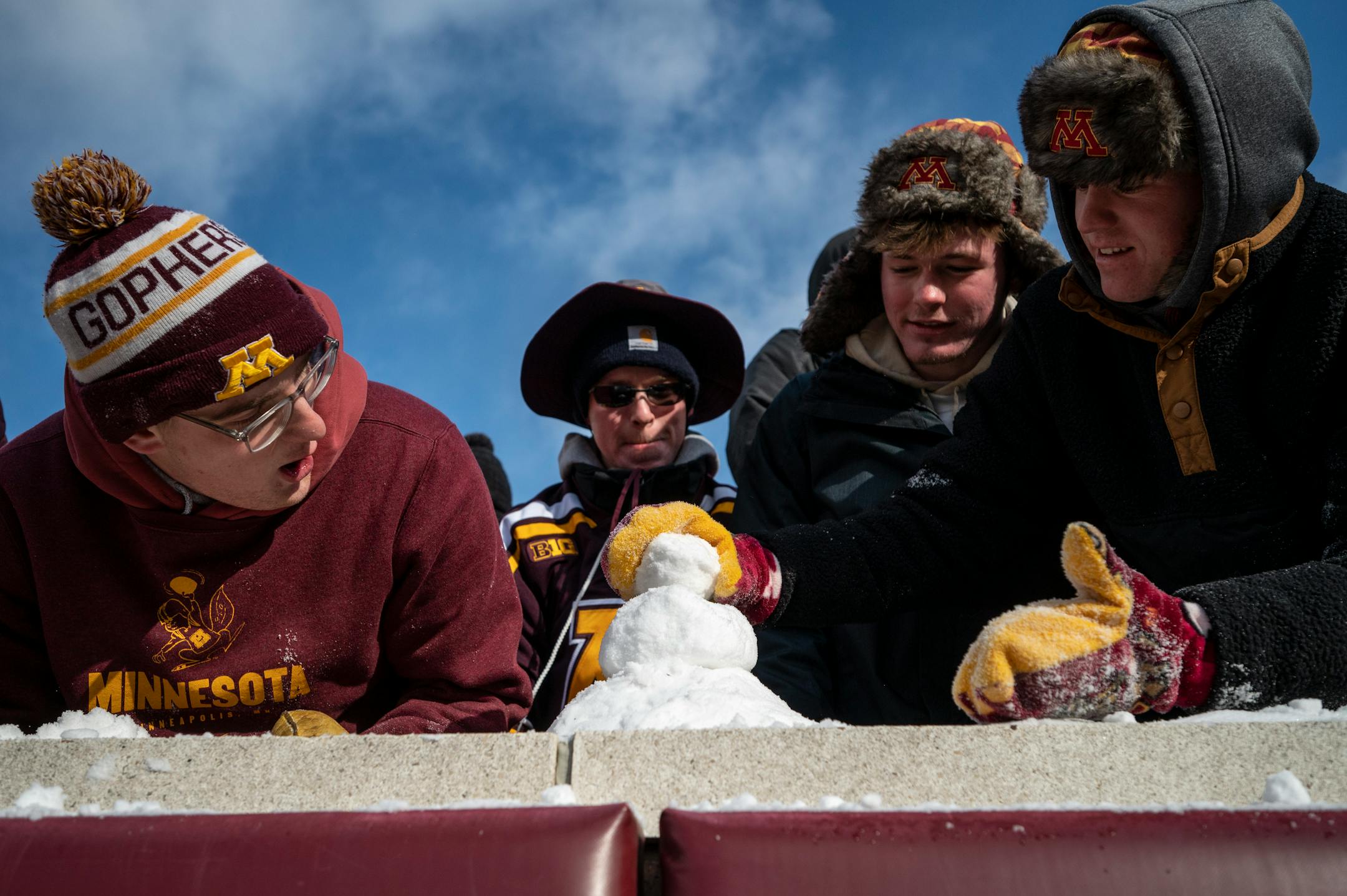 A group of Gophers fans build a snow man before the start of a game against the Iowa Hawkeyes.