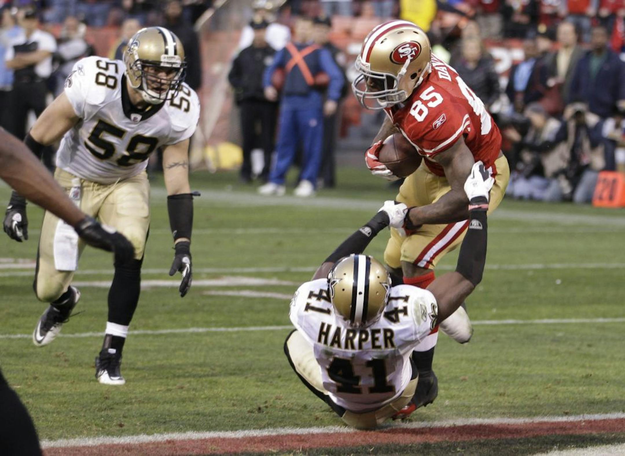 San Francisco 49ers tight end Vernon Davis (85) scores on a 14-yard touchdown pass from quarterback Alex Smith over New Orleans Saints strong safety Roman Harper (41) during the fourth quarter of an NFL divisional playoff football game Saturday, Jan. 14, 2012, in San Francisco.