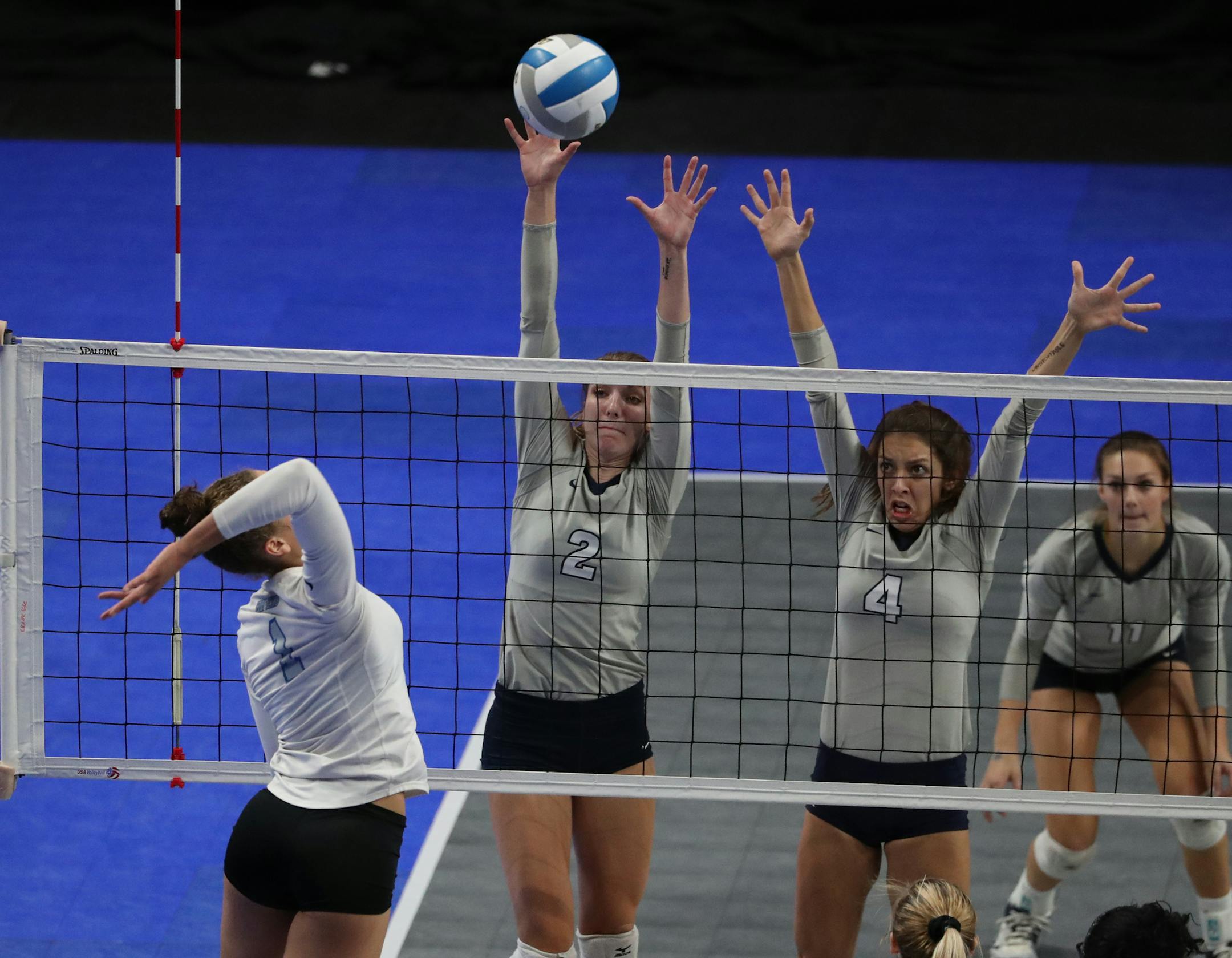 Hopkins' Jasmyn Martin goes up against Champlin Park's Sydney Hilley (2) and Maria Claflin (4).] Champlin Park defeated Hopkins in 3 sets in a semifinal match of the state high school volleyball tournament on Friday, November 11, 2016 at the Xcel Energy Center in St. Paul, Minn.