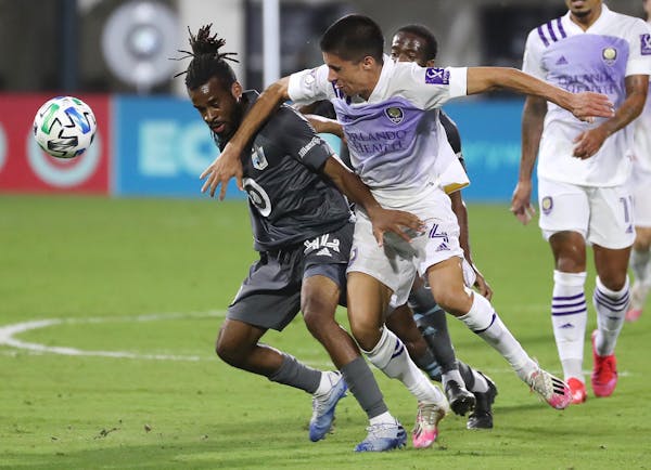 Minnesota United's Raheem Edwards, left, and Orlando City's Joao Moutinho (4) battle for positon on the ball during the MLS is Back tournament at Disn