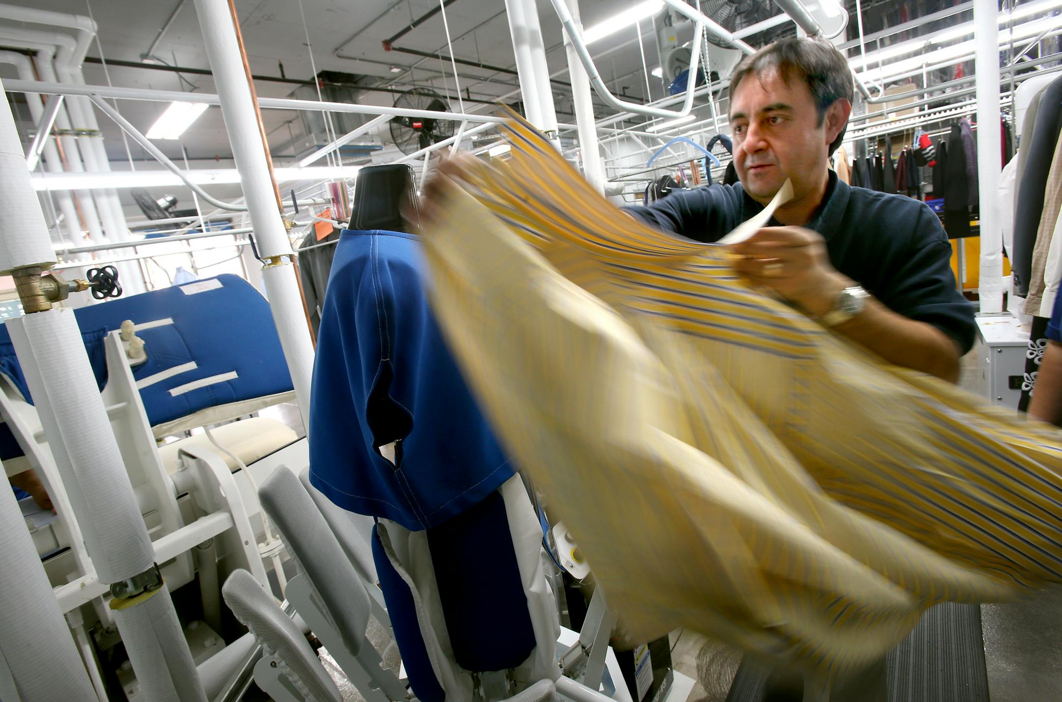 Store Manager Amjad Khan works on a shirt at CD One Price Cleaners in Hopkins.