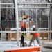 Construction workers erect the metal frame for housing at the site of the new navigation center that will replace the Hiawatha homeless encampment Wed
