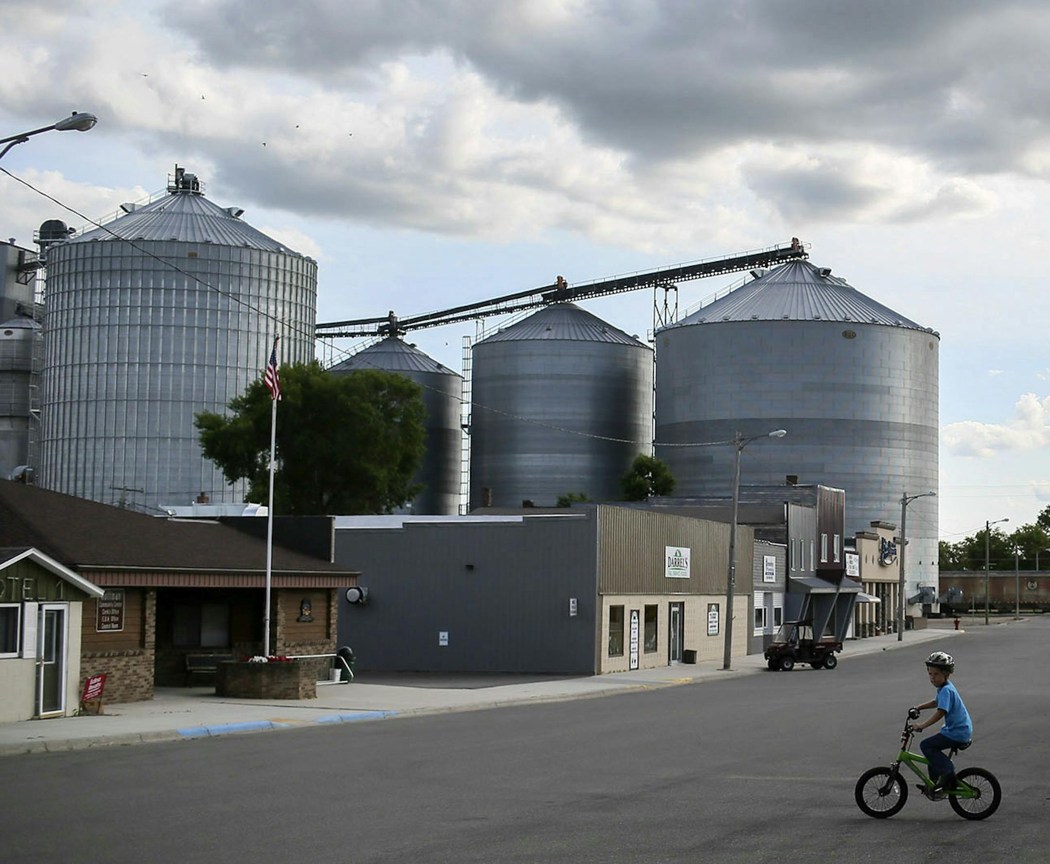 A boy bikes the main drag of Hoffman as many of the town's residents were gathered at the main Hoffman park for the weekly flea market Wednesday, July, 16, 2014, in Hoffman MN.] (DAVID JOLES/STARTRIBUNE) djoles@startribune When Muriel Krusemark, 73, moved back to her hometown of Hoffman, Minn., there were few open storefronts on Main Street. But since she became the part-time economic development director, each vacant space has been filled. It's a trick that many small towns across the Midwest w