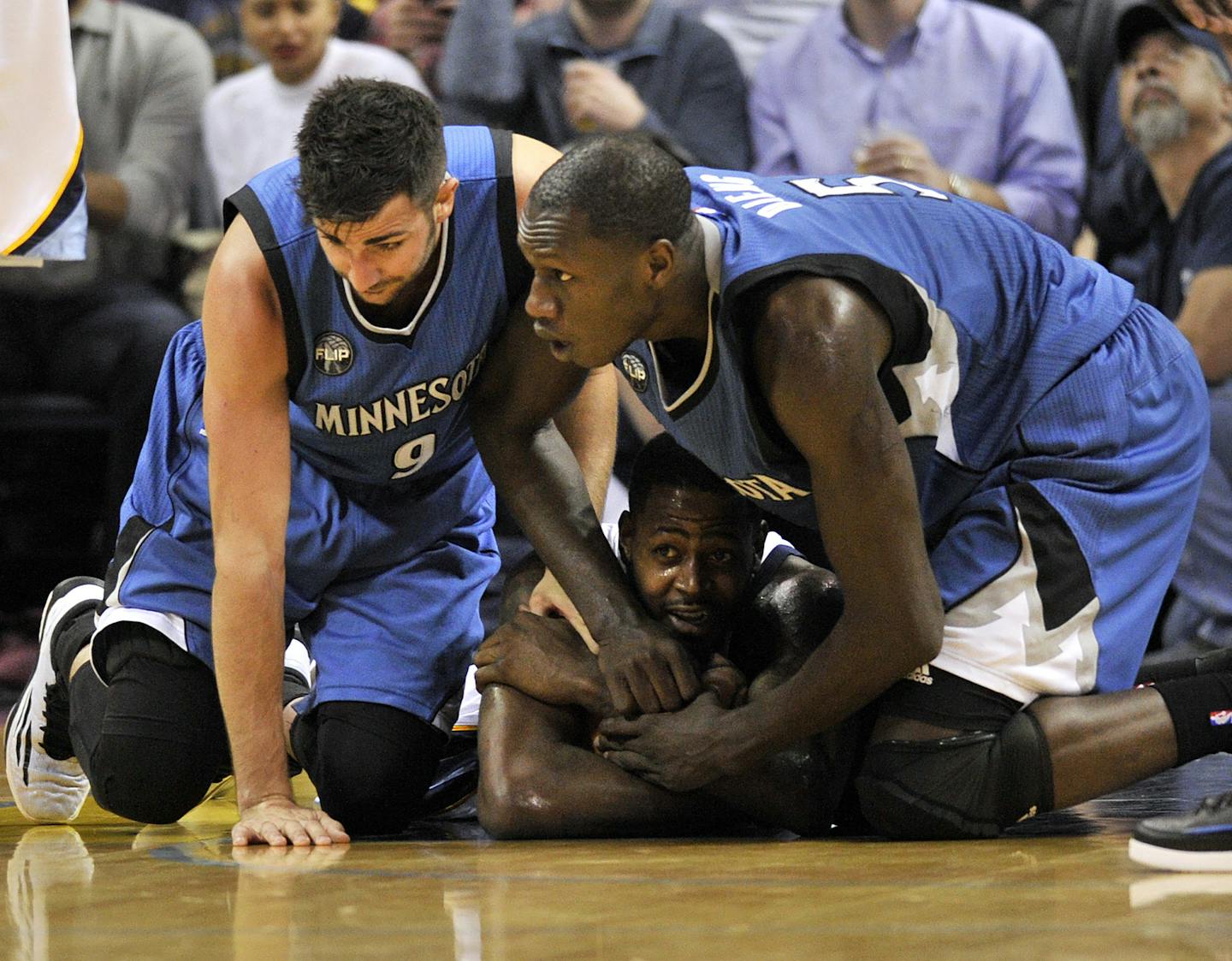 Memphis Grizzlies forward JaMychal Green, bottom, vies for control of the ball against Minnesota Timberwolves guard Ricky Rubio, left, and center Gorgui Dieng, right, in the first half of an NBA basketball game Wednesday, March 16, 2016, in Memphis, Tenn. (AP Photo/Brandon Dill)