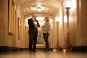 Governor-elect Tim Walz and Lt. Governor-elect Peggy Flanagan huddled in a hallway before addressing the budget surplus in a press conference.