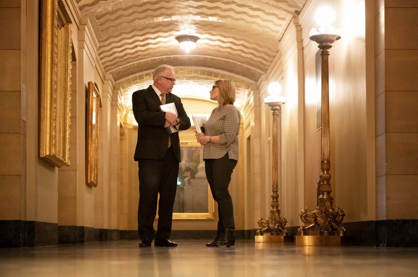 Governor-elect Tim Walz and Lt. Governor-elect Peggy Flanagan huddled in a hallway before addressing the budget surplus in a press conference.