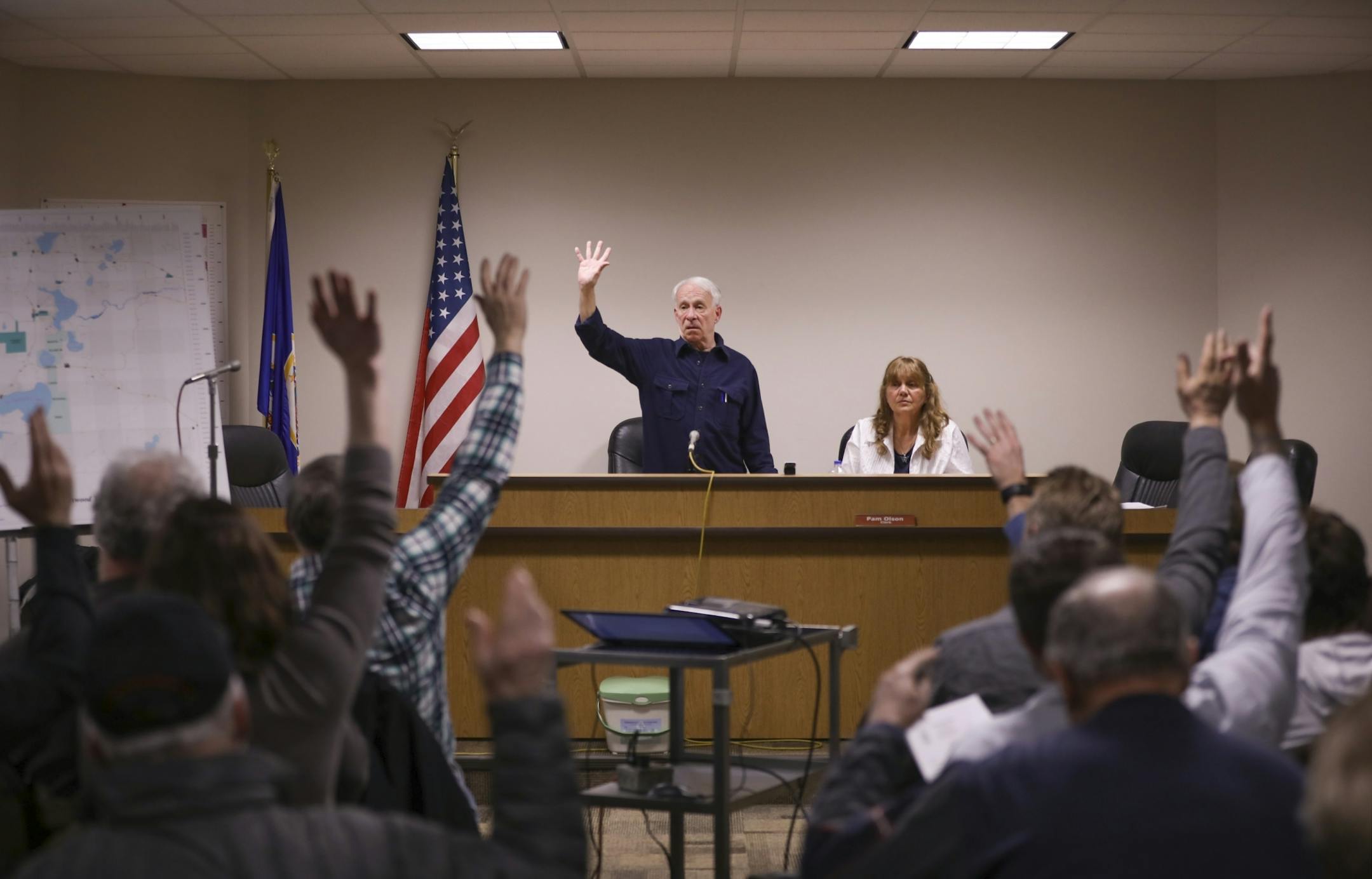 With meeting Moderator Tom Searing, standing, calling for the vote, Linwood Township residents raised their hands to vote in favor of the 2018 proposed tax levy. Town Clerk Pam Olson was seated next to him.