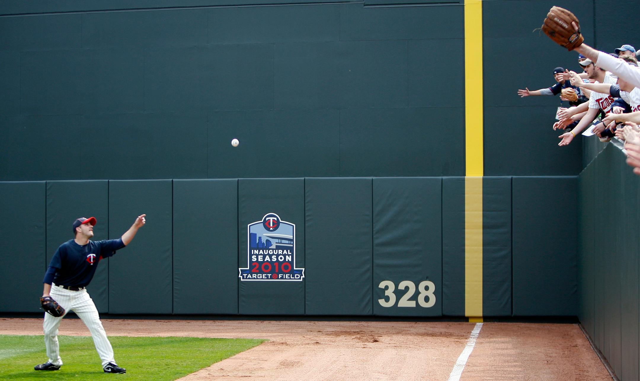 File photo: Fans reach for a ball thrown by Brian Duensing as they watched batting practice at Target Field.