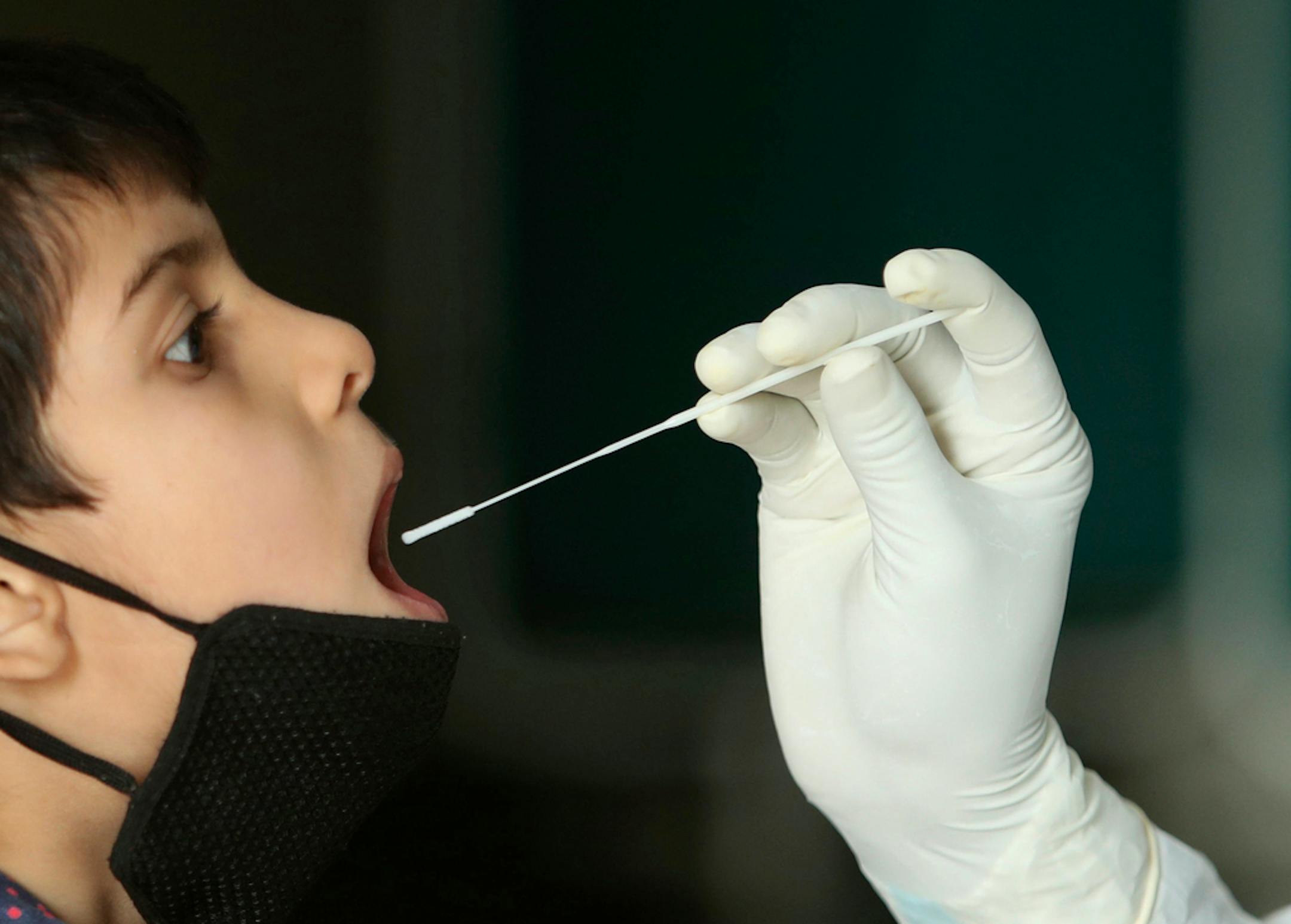 A health worker collects a swab sample to test for COVID-19 at a government hospital in Jammu, India, Tuesday, Sept. 15, 2020.
