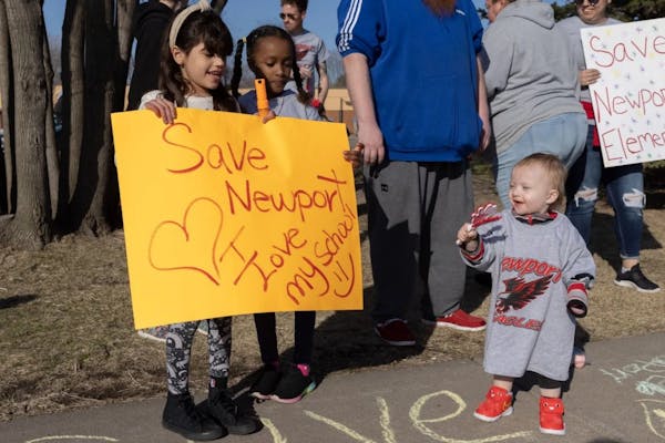 Students held signs in April 2022 asking the school board to save Newport Elementary School. 