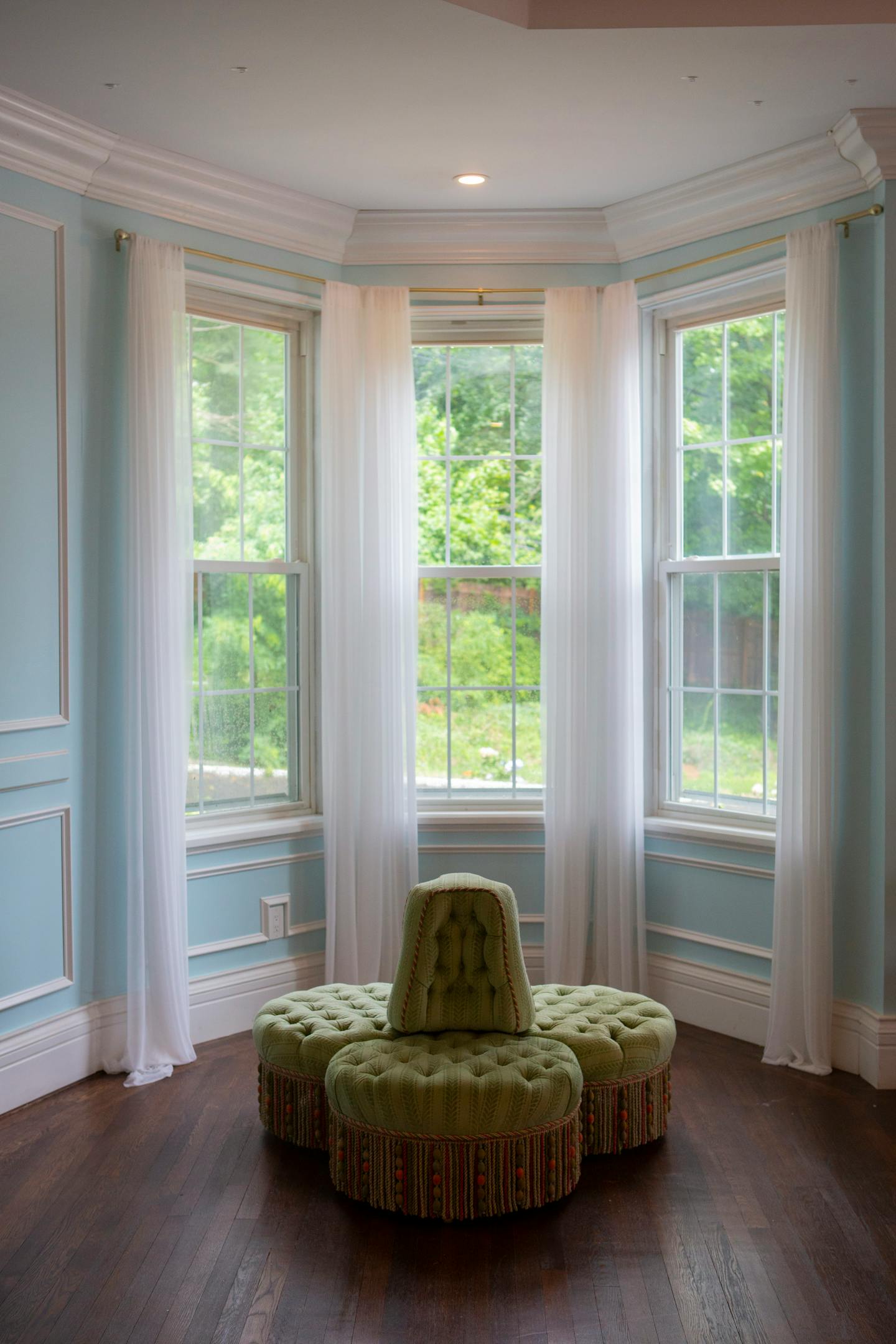 The Artys chose a bright blue paint color for the walls of this living area, and white wainscoting provides visual detail to draw the space together. Photographed July 9, 2021, in Oyster Bay, N.Y. MUST CREDIT: Photo for The Washington Post by Calla Kessler