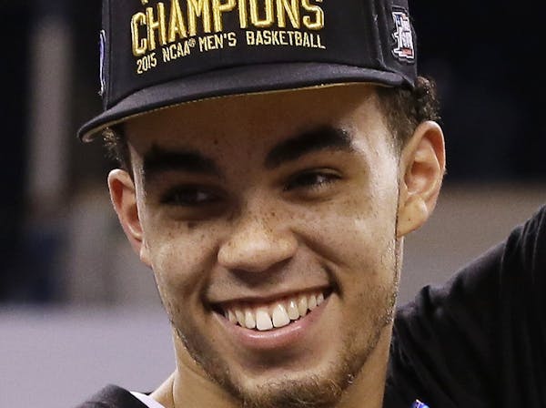 Duke's Tyus Jones cuts down the net after his team's 68-63 victory over Wisconsin in the NCAA Final Four college basketball tournament championship ga