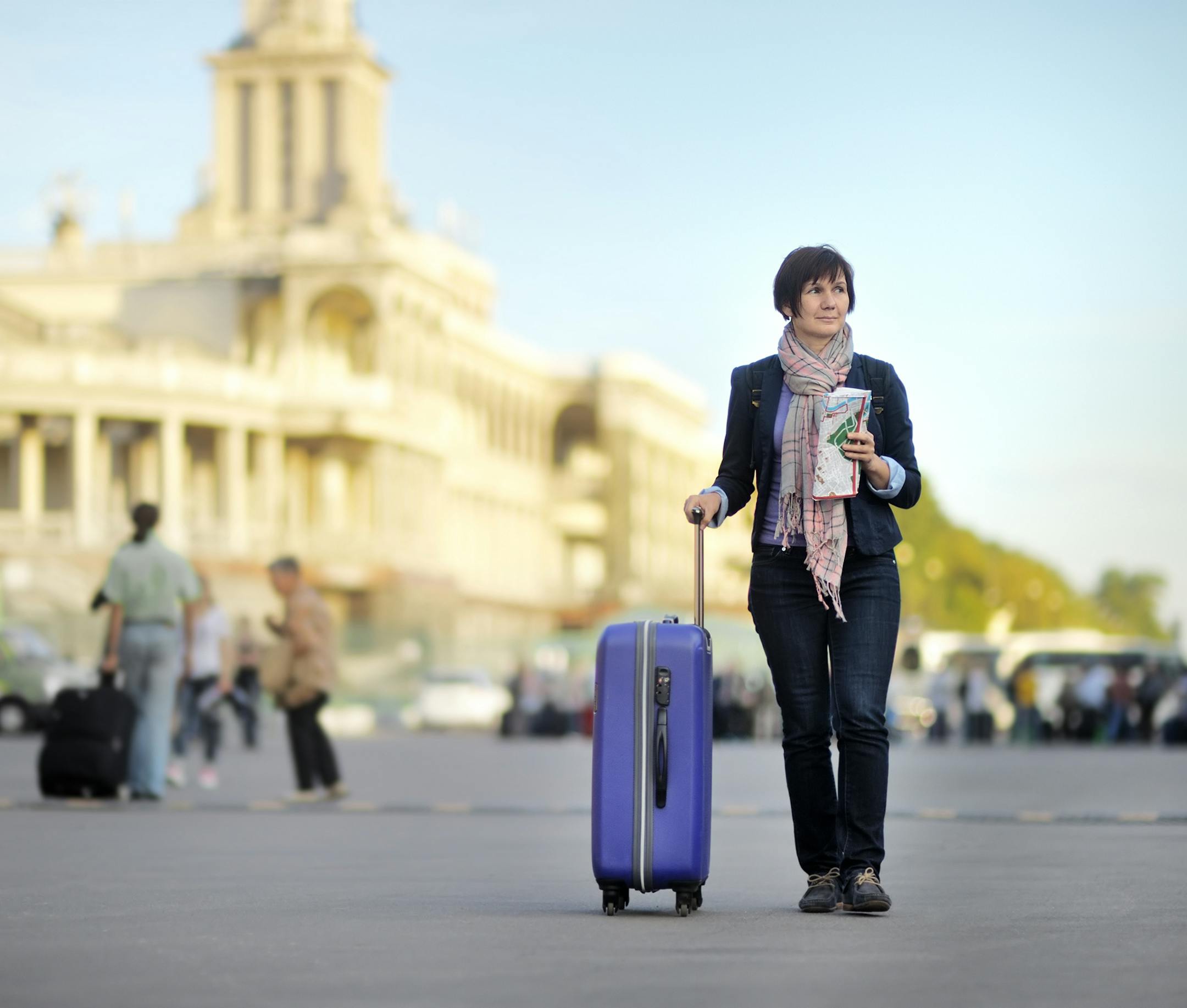 Tourist in the city (middle age woman with luggage). istock