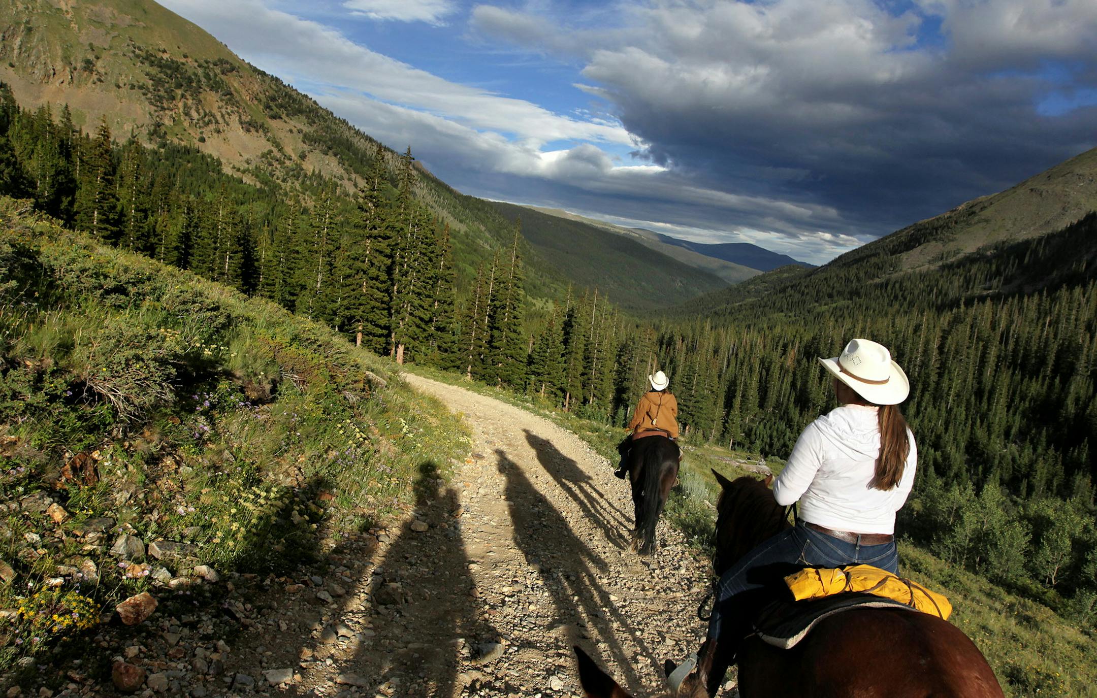 Sarah Alice Jones, 16, right, of Bend, Oregon, follows the lead of a staff wrangler as a group ventures out on an overnight trail ride from Tumbling River Ranch in Grant, Colorado, August 1, 2013. (Courtney Perry/Special to the Star Tribune)
