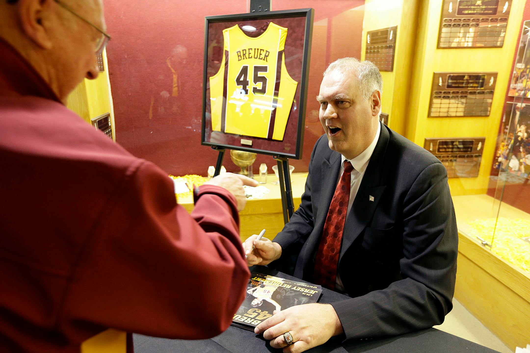 Former Minnesota and NBA player Randy Breuer signs autographs before an NCAA college basketball game between Minnesota and Illinois in Minneapolis, Saturday, Jan. 24, 2015. Minnesota is retiring Breuer's jersey at halftime. (AP Photo/Ann Heisenfelt)