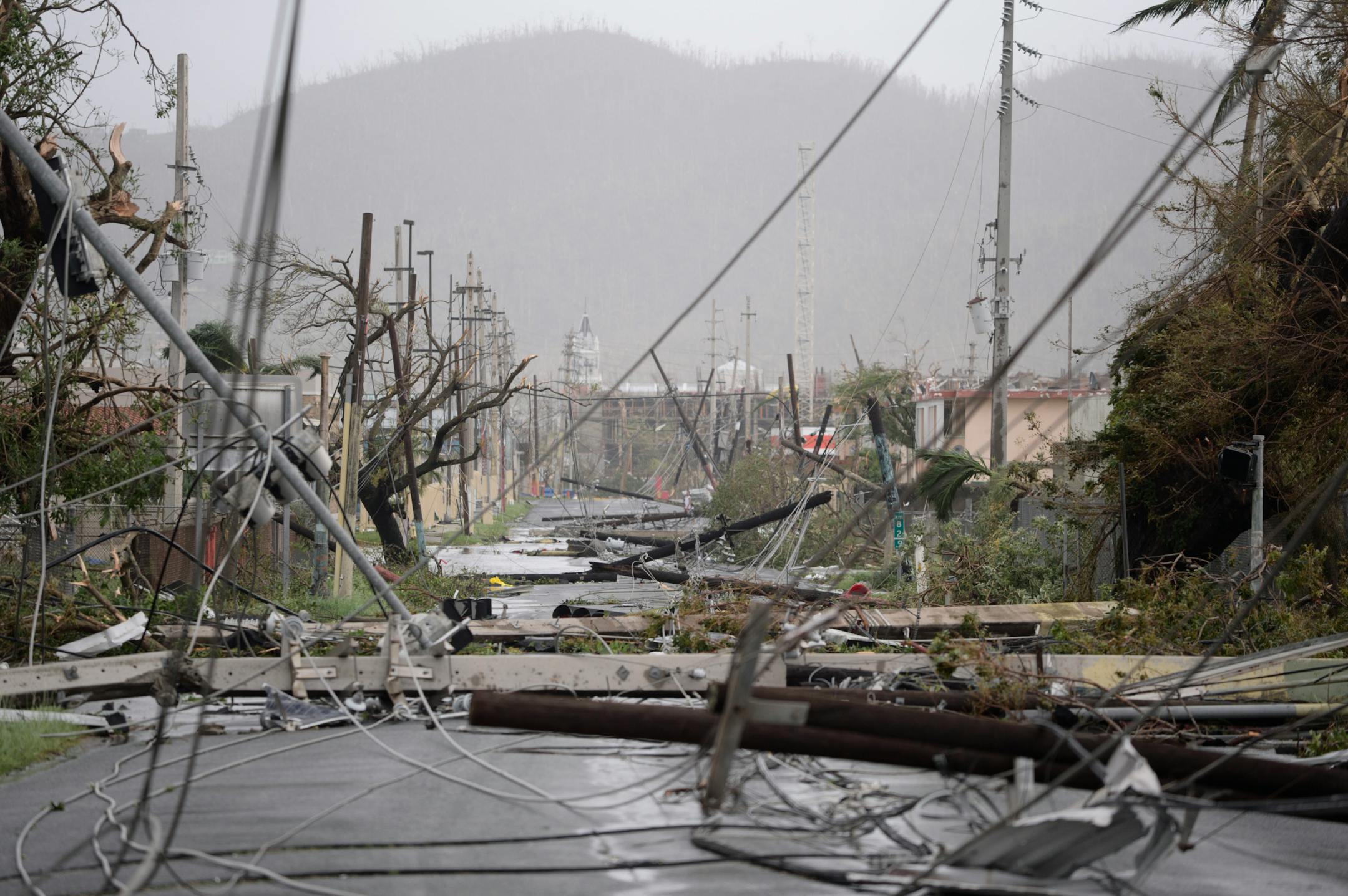 Electricity poles and lines lay toppled on the road after Hurricane Maria hit the eastern region of the island, in Humacao, Puerto Rico, Wednesday, Sept. 20, 2017. The strongest hurricane to hit Puerto Rico in more than 80 years destroyed hundreds of homes, knocked out power across the entire island and turned some streets into raging rivers in an onslaught that could plunge the U.S. territory deeper into financial crisis. (AP Photo/Carlos Giusti)