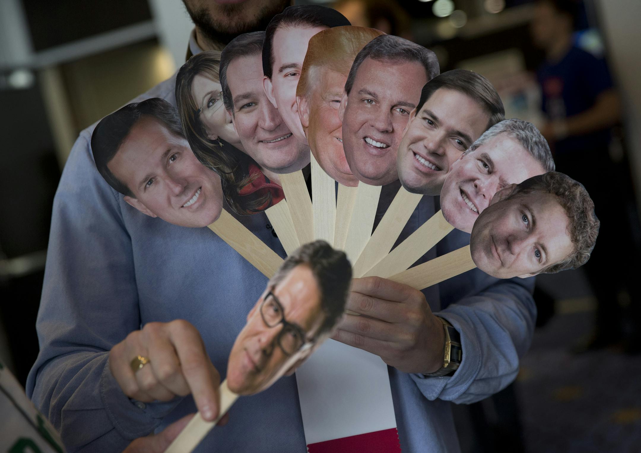 Adam Gabbatt of The Guardian newspaper holds images of possible Republican candidates, from left, former Penn. Sen. Rick Santorum, former Alaska Gov. Sarah Palin, Sen. Ted Cruz, R-Texas, Wisconsin Gov. Scott Walker, Donald Trump, New Jersey Gov. Chris Christie, Sen. Marco Rubio, R-Fla., former Florida Gov. Jeb Bush, Sen. Rand Paul, R-Ky., and below, former Texas Gov. Rick Perry, as he interviews Howard "Cowboy" Woodward holds images during the Conservative Political Action Conference (CPAC) in N